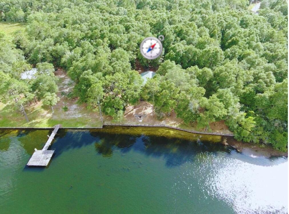 Whether you're looking for a retirement getaway, a peaceful place to live and work remotely, or a rental property, this charming cabin has it all! Private, on over 1 acre lot, plenty of space for gardening or expansion. Perfect for Airbnb or weekend retreat. Built in 2015 - Open concept, tall ceiling - Feels spacious and efficient - Nicely insulated walls - A/C Mini Split - Spacious bathroom with shower. The 12x24 covered porch elevates outdoor experience, perfectly positioned to overlook the serene waters of the lake, an ideal spot for relaxing, entertaining, or simply taking in the peaceful views. The property also features a seawall to enhance the shoreline protection, and retaining walls for added structural integrity. This lakefront heaven boasts 200 AMP electrical service with 200 AMP meter pole. Dedicated 30 AMP RV hookup, and RV direct sewage access. Gated front entrance for added privacy and security. Tucked away in the trees, but just a few minutes from US-331 N, I-10 and US-90, this recreational retreat, offers the best of both worlds - mesmerizing open views to Juniper Lake - quiet country living with outdoor adventures, such as fishing, kayaking, and boating. Quick access to town, and within an hour from world renowned Destin beaches. - Additionally, the unfinished loft offers great potential for added accommodation. Pictures of the interior will be uploaded this weekend.