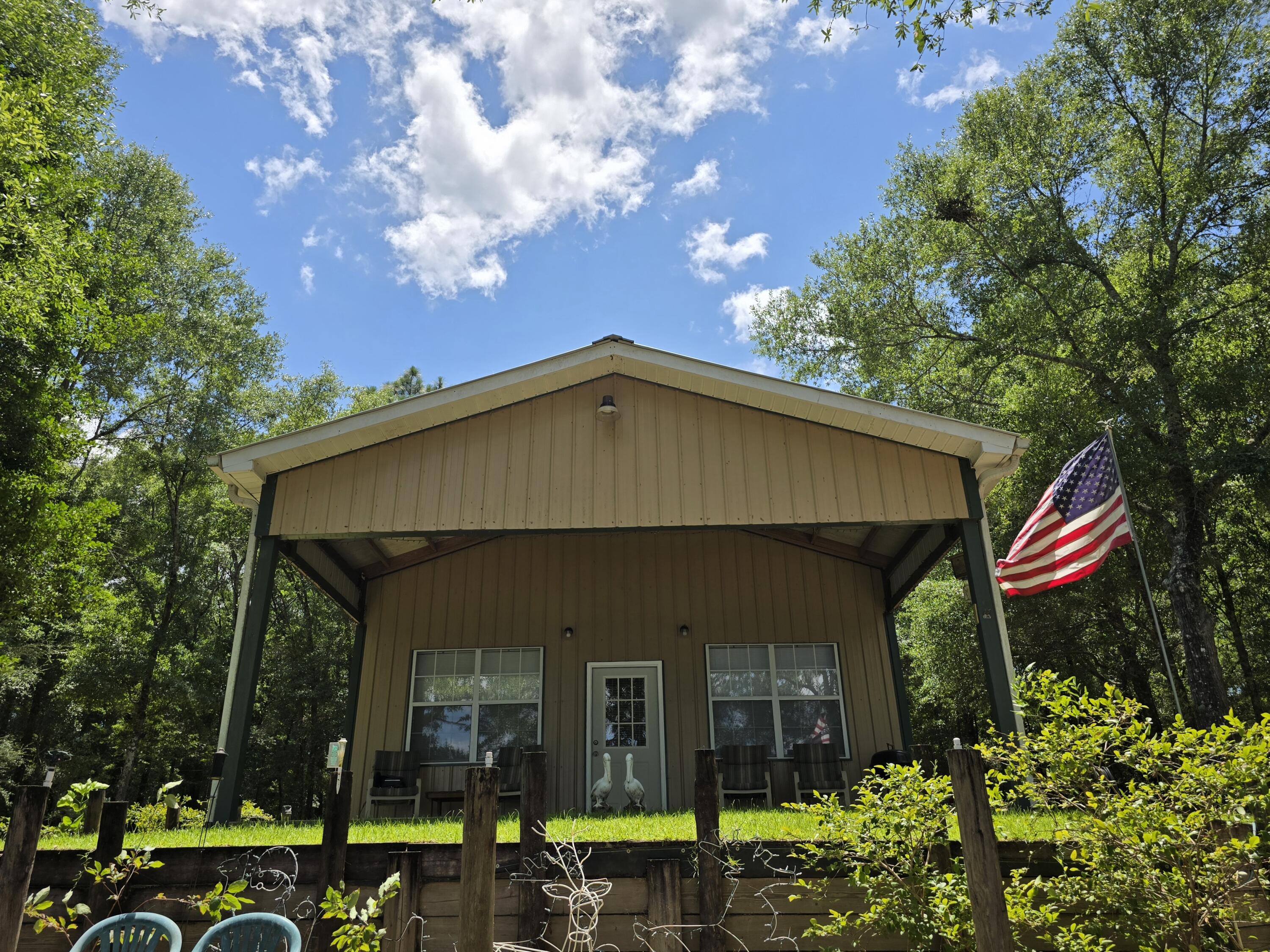 Whether you're looking for a retirement getaway, a peaceful place to live and work remotely, or a rental property, this charming cabin has it all! Private, on over 1 acre lot, plenty of space for gardening or expansion. Perfect for Airbnb or weekend retreat. Built in 2015 - Open concept, tall ceiling - Feels spacious and efficient - Nicely insulated walls - A/C Mini Split - Spacious bathroom with shower. The 12x24 covered porch elevates outdoor experience, perfectly positioned to overlook the serene waters of the lake, an ideal spot for relaxing, entertaining, or simply taking in the peaceful views. The property also features a seawall to enhance the shoreline protection, and retaining walls for added structural integrity. This lakefront heaven boasts 200 AMP electrical service with 200 AMP meter pole. Dedicated 30 AMP RV hookup, and RV direct sewage access. Gated front entrance for added privacy and security. Tucked away in the trees, but just a few minutes from US-331 N, I-10 and US-90, this recreational retreat, offers the best of both worlds - mesmerizing open views to Juniper Lake - quiet country living with outdoor adventures, such as fishing, kayaking, and boating. Quick access to town, and within an hour from world renowned Destin beaches. - Additionally, the unfinished loft offers great potential for added accommodation. Pictures of the interior will be uploaded this weekend.