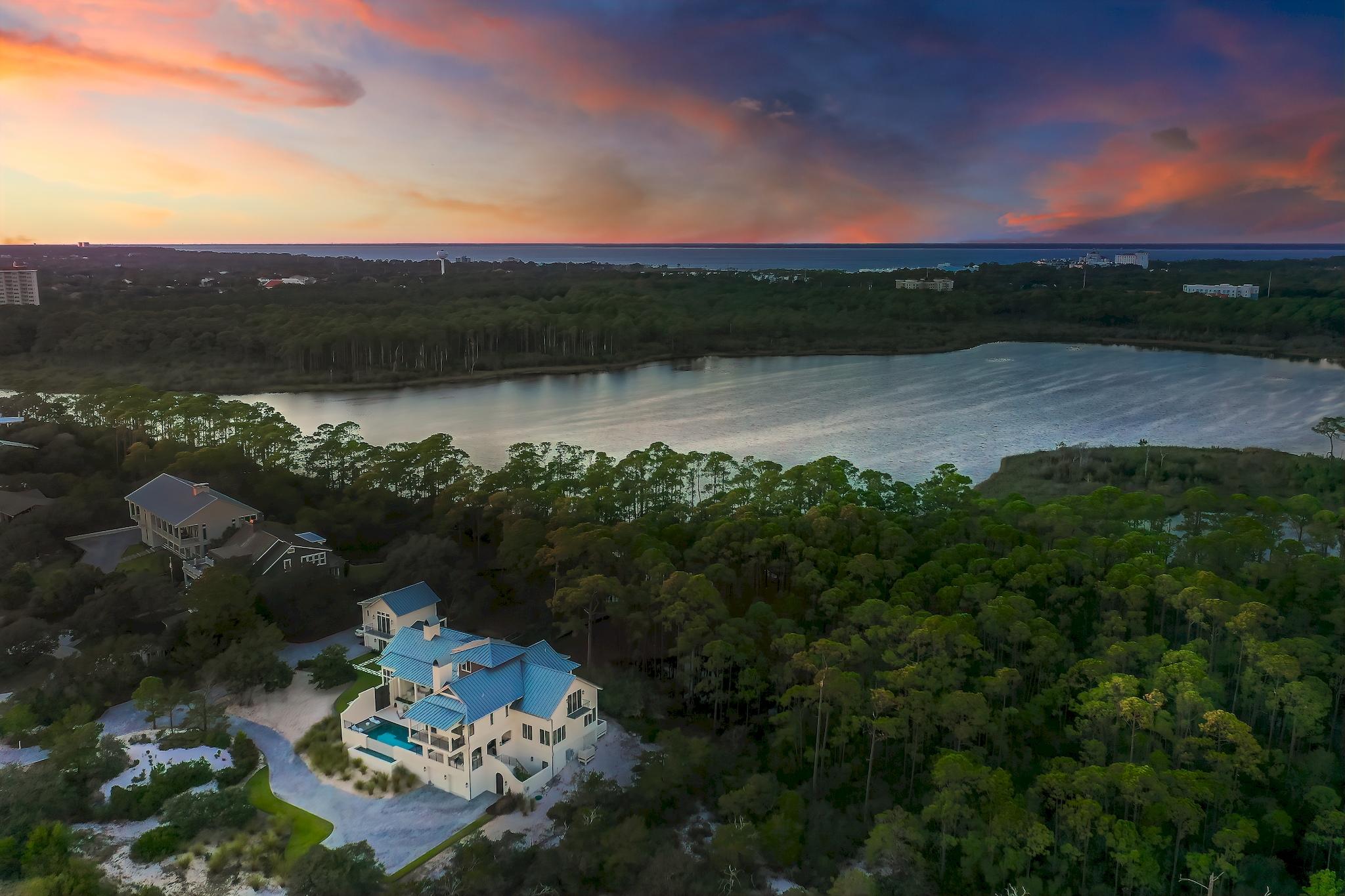 Imagine a home so sheltered by nature that a mother deer and her fawn amble slowly by the window headed to the rare coastal dune lake that serves as the northern boundary. Gaze from the open-air balcony across seemingly endless white sand dunes that wind to the shimmering emerald waters of the Gulf of Mexico. Truly a one-of-a-kind opportunity in Northwest Florida, 285 Twisted Pine Trail offers all of this and much more, all located within minutes of first class dining and entertainment. Situated on just under three acres in the gated sanctuary of Four Mile Village, this property is also bordered by Topsail Hill Preserve State Park offering an incredible sense of seclusion. An exquisite Geoff Chick design expertly constructed in 2017 features panoramic views of Fuller Lake and the Gulf of