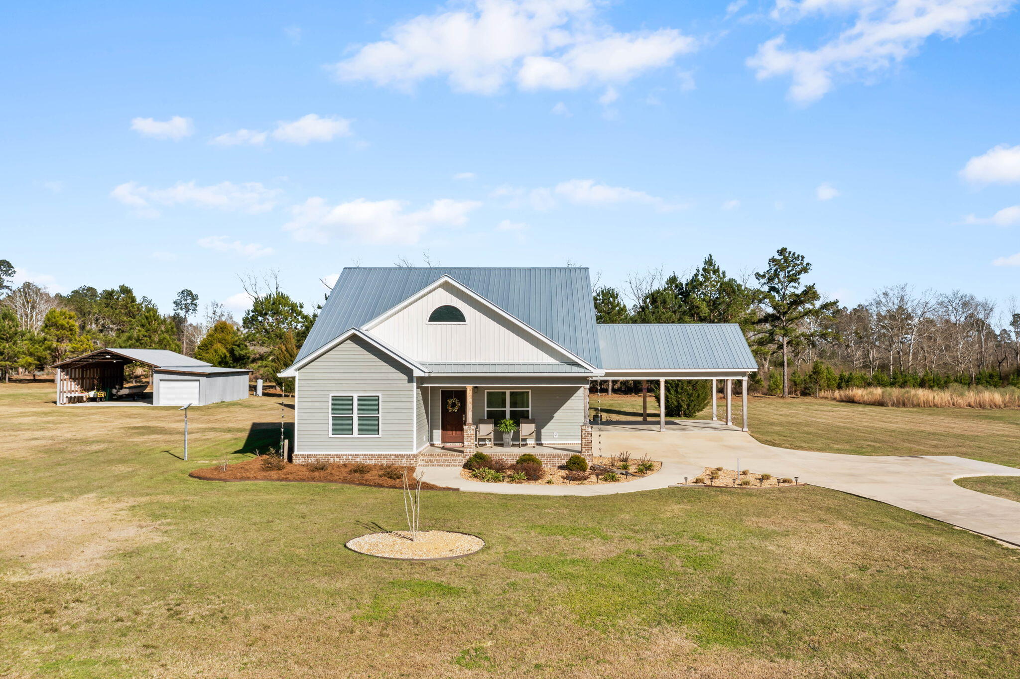 Beautiful and well kept home in the prestigious Lakepointe Subdivision is a true gem.  This 4 bedroom, 2.5 bath home offers an open concept, front and rear porches, a carport to entertain at and a covered/enclosed barn on the back of the landscaped two acres.