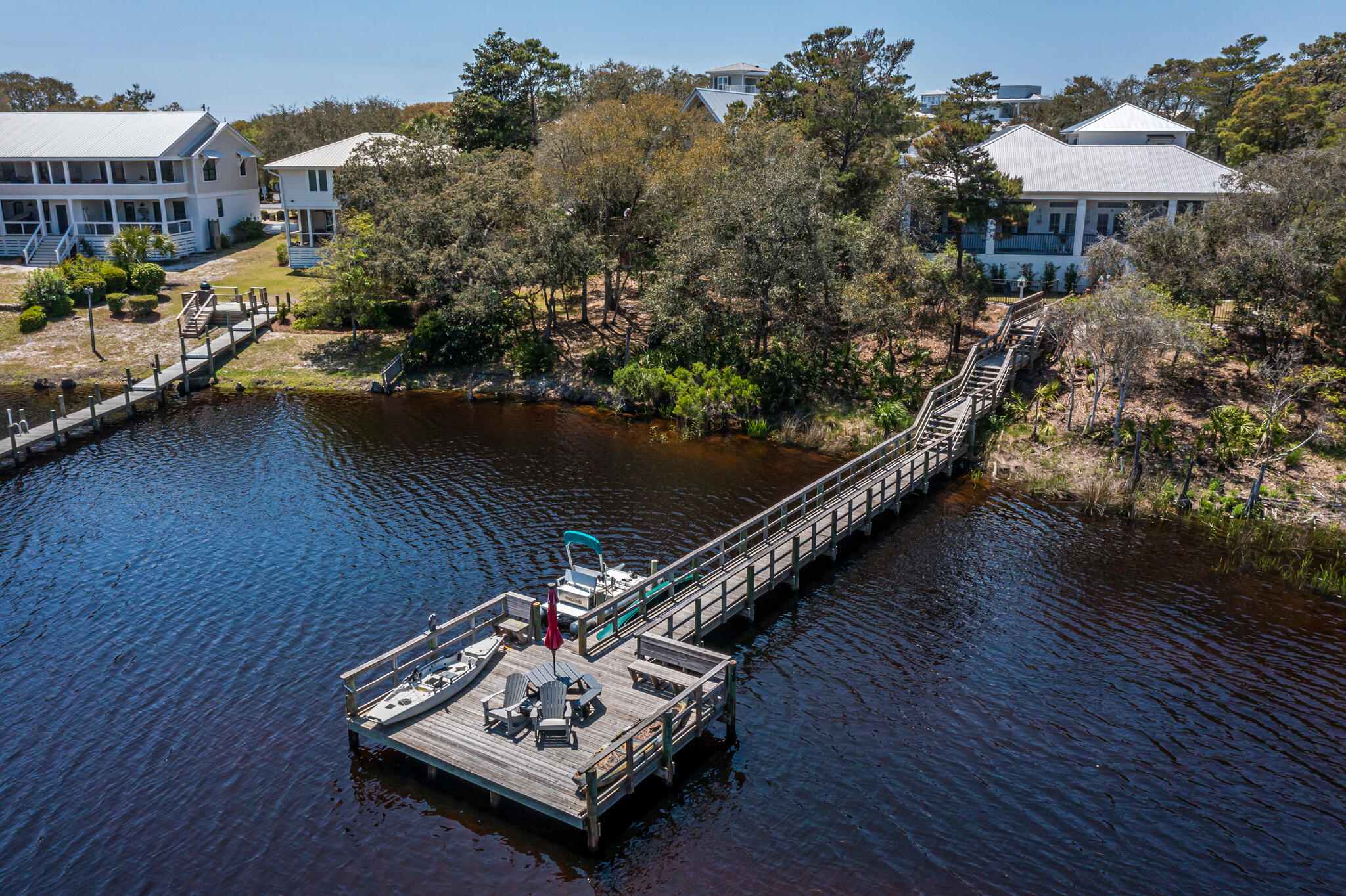 Beautiful Lakefront Property in the desirable Blue Mountain Beach Subdivision with NO HOA. MOVE IN READY, it has been cleaned out and ready for its new owners. This is a great house with lots of custom touches and would be a dream come true for any water lover. A 3 tier pier dock on the Coastal Dune Lake with multiple deeded, private beach accesses in the neighborhood, plus a screened in, gunite pool. The main home is 1916 sq ft and was built in 2018; it has 2 beds/2.5 baths and an 850 sq ft screened in, covered back porch with outdoor kitchen area. There is an additional 506 sq ft Carriage House over the detached garage that was built in 2024; perfect for guests. It is complete with 1 bed/1 bath; a living room/full kitchen combination, with both AC/Heat. See the Property Flyer and list of Features in the Documents Section for additional information. The Sellers are leaving the large gun safe that is in the air-conditioned room in the garage; the paddle boat, the canoe, the polywood table on the dock, and the heavy duty industrial grade- yet removable kid gate by the pool.