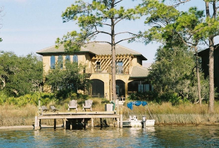 This beautiful Waterfront Estate, located within the private gated enclave of The Lakeplace in Grayton Beach, faces the tranquil Western Lake and the Gulf of Mexico. The original owners offer this immaculate custom-designed stucco Home, constructed with concrete blocks with tile roof. The residence is perfect for entertaining, with Southern exposure and a well-conceived open floor plan that includes: 22 foot high coffered Ceilings, tall 2 story Windows, a full Bar, state-of-the-art Kitchen with granite counter tops, 3 Fireplaces, an inviting Screened Porch, a Terrace with hot tub and a main floor Master Suite. A separate Office with custom cherry built-ins complete the main floor. The second floor features two en-suite Guest Bedrooms and a private Veranda overlooking the Lake and Gulf.
