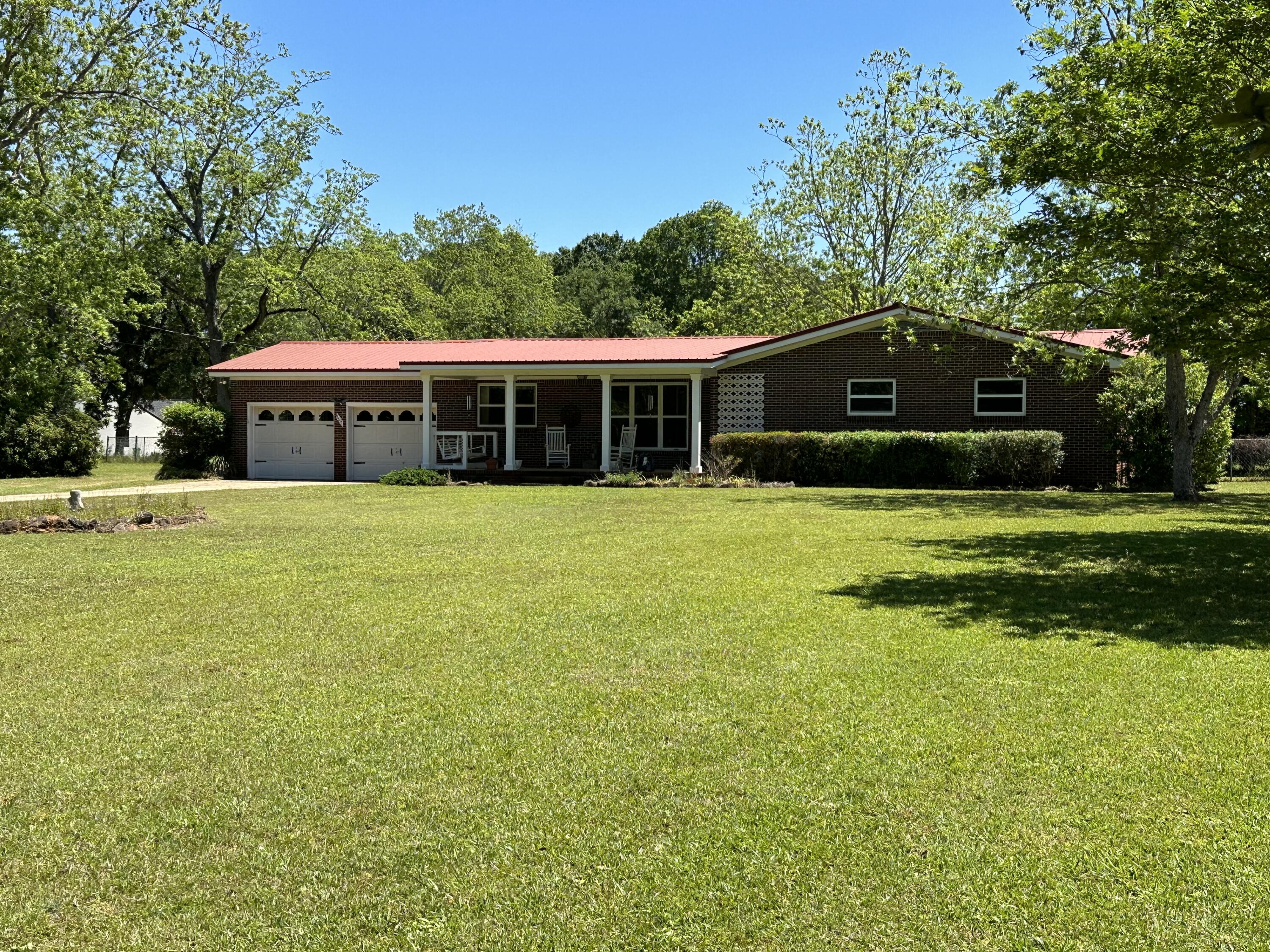 Welcome to your dream home! Imagine sitting on the porch, taking in the stunning view of this 3/4 +/- acre lot. This beautiful 3 bedroom brick home with a metal roof boasts a double garage, a barn, and even a she shed - everything you need for the ultimate lifestyle. And the best part? It's located on the desirable North end of town. Don't miss out on this incredible opportunity.