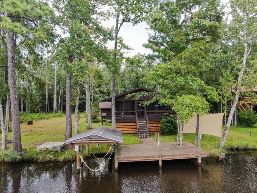 FISHERMAN'S PARADISE.  Waterfront cabin on Alaqua Creek,  a fresh  water tributary that runs  into Alaqua Bayou and  then the bay.    Excellent fishing for  bass, bream, shellcracker, red fish, speckled trout and flounder!  The cabin is in excellent  condition!  You will love the screened in  porch that  overlooks the creek.  Boat owner friendly with its upgraded dock & boat house that includes a new boat lift installed in 2020.  A county maintained boat ramp is only 100 yards from the house  making it very  easy to put in or take out your boat when necessary.  Concrete block garage has its own half bath.  New home inspection, 4pt inspection, wind mitigation inspection,  septic inspection, & well inspection available.  shown  by appt. 24 hours notice