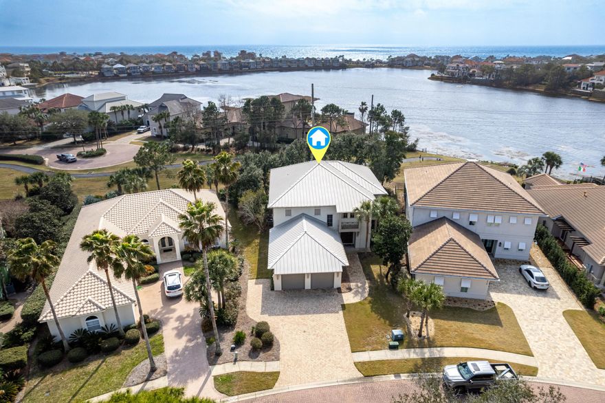 Price improvement and lowest price per square foot in the prestigious gated beach community of Destiny East. This large, quality custom  home, built by Magnolia Custom Homes, is perfectly situated on an easement with large trees and lake views, allowing back yard privacy. It has been impeccably maintained and all of the wiring is in place for you to customize your own outdoor pool oasis. This home is perfect as a primary, secondary or investment property. There is plenty of space for guests with 5 bedrooms, 4 with ensuite baths, including two masters and a bunk/media/game room that will accommodate a pool or ping pong table. Enjoy paddle boarding behind your back yard across the lake and over to the beach! The first floor offers a large open plan with the living, dining room and kitchen overlooking the lake. The gourmet kitchen boasts beautiful white marble countertops, a large heart pine topped island, custom cabinets, an ice machine, and a large 6 burner Jenn Air range with double ovens and a griddle.  French doors lead to the patio for entertaining and grilling. The first floor primary bedroom has a large walk in closet with a stackable washer and dryer for convenience.  The bath is spacious with a large shower and double vanities. A convenient mud room with an extra refrigerator leads to the garage. The back porch offers the perfect spot for al fresco dining. Upstairs, beautiful 3/4 inch solid hardwood floors wind seamlessly throughout the rooms. The larger primary bedroom enjoys a balcony overlooking the back yard and the lake.  Enjoy his and hers closets, a large shower, soaking tub, double sinks and a sit down vanity.  The other spacious guest rooms are on this level as well as the bunk/game room.  Kids can have their own space for slumber parties, games and movies.  A nice laundry room across from the game room is set up for easy entertaining, complete with cabinets, a small refrigerator, sink and a microwave. A large walk in attic allows for convenient access to stored items. A built in vacuum system allows for quick and easy cleaning. Destiny East is conveniently located near the beach, restaurants and shopping.  Take your golf cart or bike to the beach for endless fun and relaxation. The neighborhood's two gates make it convenient for access from the scenic beach road or Highway 98. Destiny East has world class amenities including a large club house with a theater, party room, kitchen, and gym. The two lighted tennis courts are also lined for pickle ball. The large pool and hot tub are next to the wonderful children's play ground.  A grilling area allows for fun dinners to be served while playing. At 4250 square feet, this is a great value for a large home in Destiny East and one of the lowest priced homes per square foot!  Photos have been virtually staged however this home is being sold furnished, as per the last photos with actual furnishings. Make an appointment today!  All measurements and information to be verified by the buyer and buyers agent.

