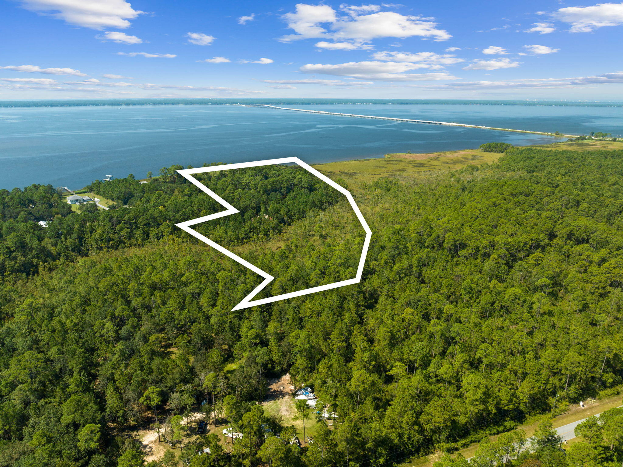 Spread across a private and stunning 10.61 acre property with 357 feet of Bay frontage offering breathtaking water views and endless potential. Whether you envision a serene waterfront retreat, a custom estate, or a boutique mini farm, this extraordinary land can make your dreams a reality.Featuring a 3,000-square-foot two story enclosed barn and a spacious pole barn, the property blends functionality with charm. With deep water access to Choctawhatchee Bay and close proximity to the world-famous white sand beaches of 30A in Walton County, this is a rare opportunity to own a slice of paradise.Situated in the sought-after Freeport area, the property is graced with century-old oak trees, magnolias, and palmetto palms, evoking the timeless beauty of Old Florida.