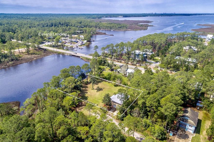 Build your dream home on this gorgeous secluded .55 acre deep water lot on Hogtown Bayou while you live in your 3BR/2BA, 1000 sq.ft. carriage house with an oversized two-car garage. Open-concept floor plan. Hardwood floors in all bedrooms. Ceramic tile in kitchen, baths, living & dining room. Kitchen has granite countertops & lots of cabinets. Two front porches. Top one has a Sunsetter retractable awning. Stucco & Hardi-plank siding with metal roof. High-end wood & wire fencing surrounds the lot. Lots of trees, natural vegetation and well-maintained gardens. Lot is high and dry and has 125 ft of water frontage with amazing bayou views. Wooden dock. Perfect for small boating, kayaking, paddle boarding & fishing in the bayou or bay. No HOA fees. MUST VIEW PHOTOS TO APPRECIATE PROPERTY.