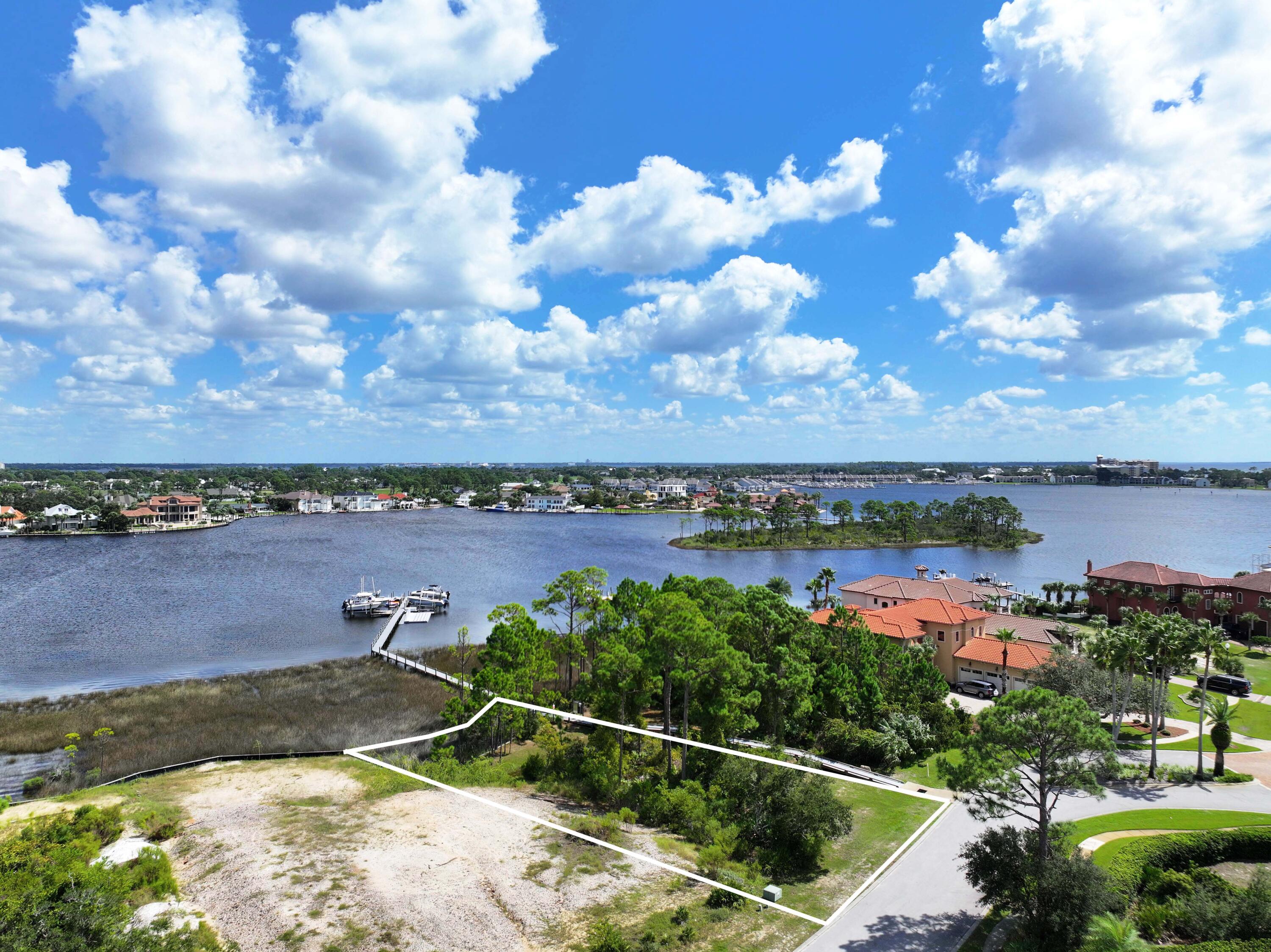 Come and build your dream waterfront home on Grand Lagoon in Panama City Beach! This gorgeous home site is located in Finisterre, a gated waterfront neighborhood with fabulous amenities and perfect location where you can walk to nearby restaurants. Enjoy amenities such as tennis, pickleball, basketball, a playground, and community dock. So close to restaurants, grocery, St Andrews State Park, boating, and of course, the beautiful beaches of Panama City Beach! The adjacent lot is also for sale (see MLS #966125), offering you the opportunity to obtain 2 side by side lots in one of the most prestigious neighborhoods in Bay County. Please check in to any measurements or utilities to confirm information. Call today!