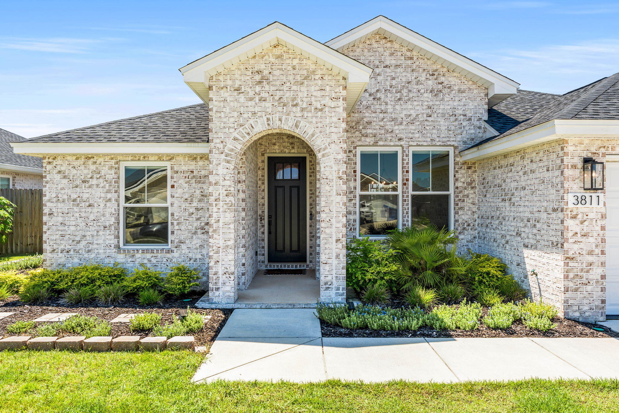Welcome to 3811 Redbud Way, a stunning Rollins floor plan custom-built by Camben Homes in 2023, offering a blend of modern luxury and timeless craftsmanship. Located in the highly sought-after College Station community, this home has been thoughtfully designed with premium upgrades inside and out. The curb appeal is unmatched, featuring Xoysia grass, extensive landscaping with over $12,000 invested in mature palms and lighting, and a fully integrated irrigation system. The property is served by underground utilities, giving the neighborhood a clean and upscale feel. Step inside and you'll find a bright, open-concept layout that showcases high ceilings, Low-E windows, designer fixtures, and custom details throughout.