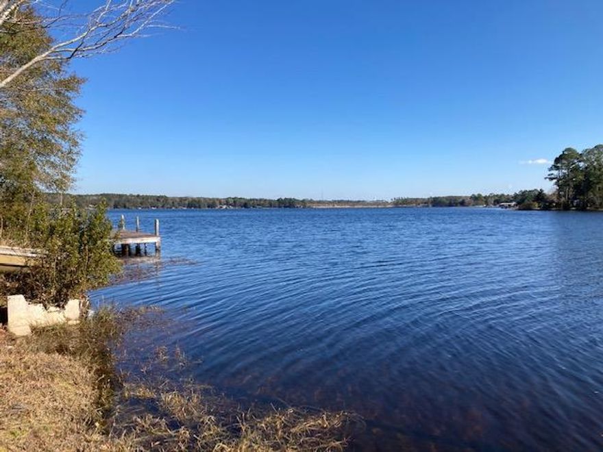 HARD TO FIND WATERFRONT LOT ON LAKE JUNIPER.  This .44 acre lot has a fantastic waterfront view of the main channel.  Lake Juniper is a flooded timber lake, and its the ONLY State maintained lake in north Walton! This means the State maintains the dam and the water level with NO HOA fees.  It's a great fishing lake full of bass, brim and crappie. Stick built homes or mobile homes are allowed.  There is public water on site per the City of DFS (tap fee is paid). There is an old chain link fence, a power pole, and old septic tank (condition is questionable), along with a dock (condition unknown), and a storage building. This one won't last long!