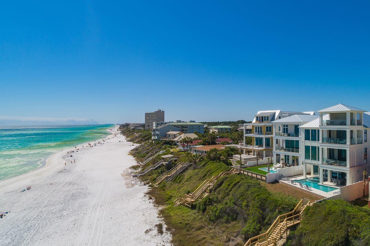 Newly completed and primely positioned this sleek coastal contemporary Gulf front compound is perfectly situated in the heart of Seagrove Beach characterized by panoramic beach views from each of it's impressive three levels as well as the covered fourth story rooftop deck. This is the ultimate beach home; configured to provide unparalleled amenities and optimized for entertaining with notable features including a resort style gulf front pool area & spa situated almost 25' above the beach yielding unmatched water views as well as optimal privacy. This incredible home is situated on a massive oversized 52x390' homesite allowing for a private parking court with two car garage (with additional storage) as well as a golf cart garage in the carriage house.