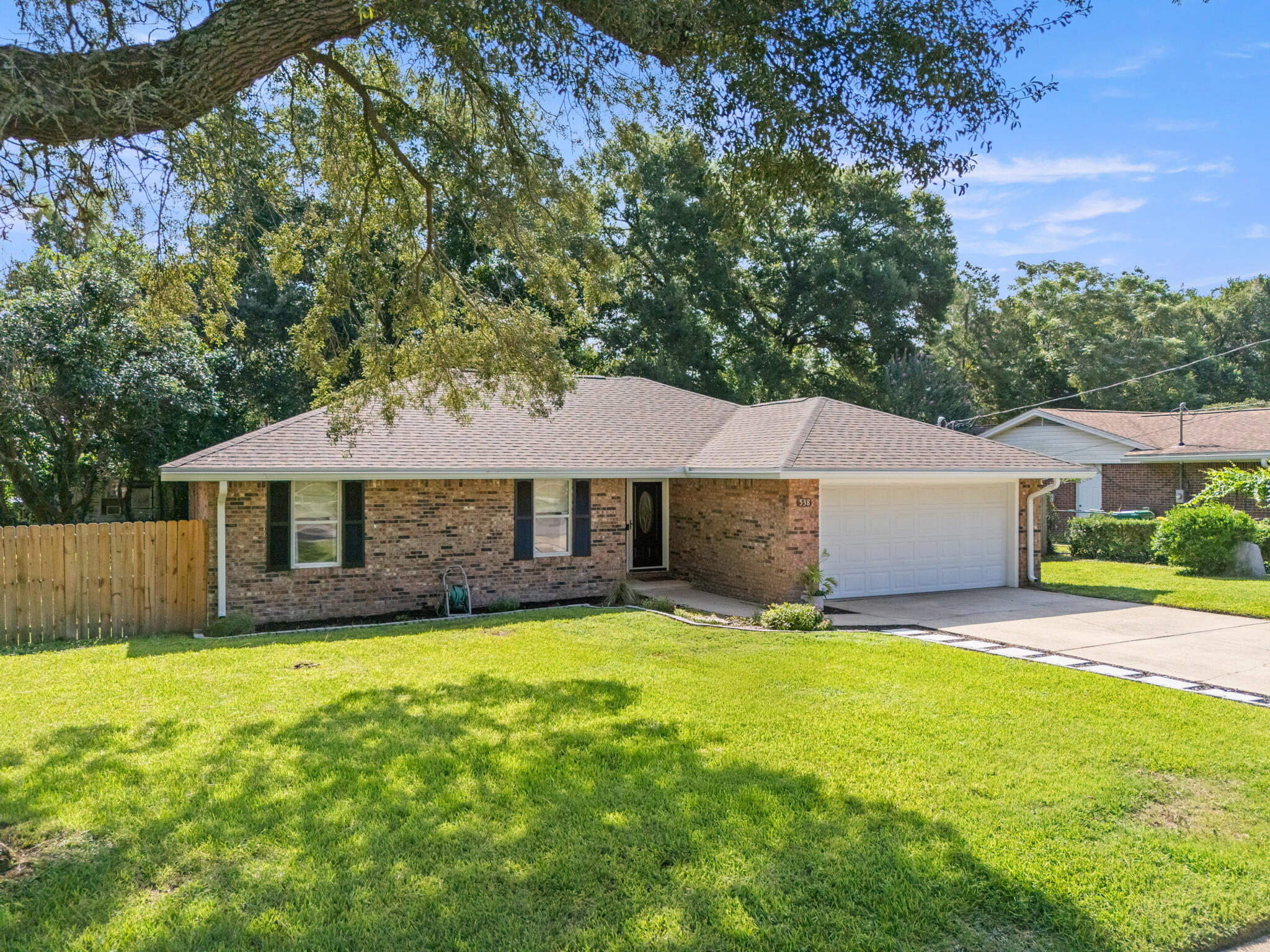 Renovated to Inspire. Staged to Impress. Move-In Ready in Niceville's Carol Ann Manor.On a corner lot in one of Niceville's established neighborhoods, this 2,021 sq ft home blends mid-century character with a sleek, modern revival. Originally built in 1974, it was taken down to the studs and completely reimagined inside and out so you can enjoy the charm of the era without sacrificing today's style or convenience.The kitchen is the showpiece, with quartz countertops, a large center island with hidden storage, open shelving in place of upper cabinets, and textured subway tile that adds depth and dimension. The custom butler's pantry with butcher block counters and smart organization handles the extra storage with ease. An open layout flows through the dining area and into the sunken family room, where a wood-burning fireplace anchors the space. Luxury vinyl plank flooring, designer fixtures, and hand-selected finishes give the home a fresh and intentional feel throughout.
The main bathroom offers everyday luxury with a double vanity featuring brushed brass fixtures, era-appropriate designer tile, and a fully tiled shower and tub combination. The primary suite features two sunlit windows, a walk-in closet with custom organization, and a striking ensuite with ceiling-height tile, a sleek vanity, and glass barn doors.
Enjoy Florida living year-round in the enclosed Florida room, perfect for morning coffee or evening relaxation. The backyard is shaded by mature trees and enclosed by a brand-new privacy fence.
With updates including a new roof, upgraded electrical, custom closets, and thoughtful finishes from top to bottom, this home stands apart from anything else on the market in Niceville. Renovated, staged, and ready for its next chapter.