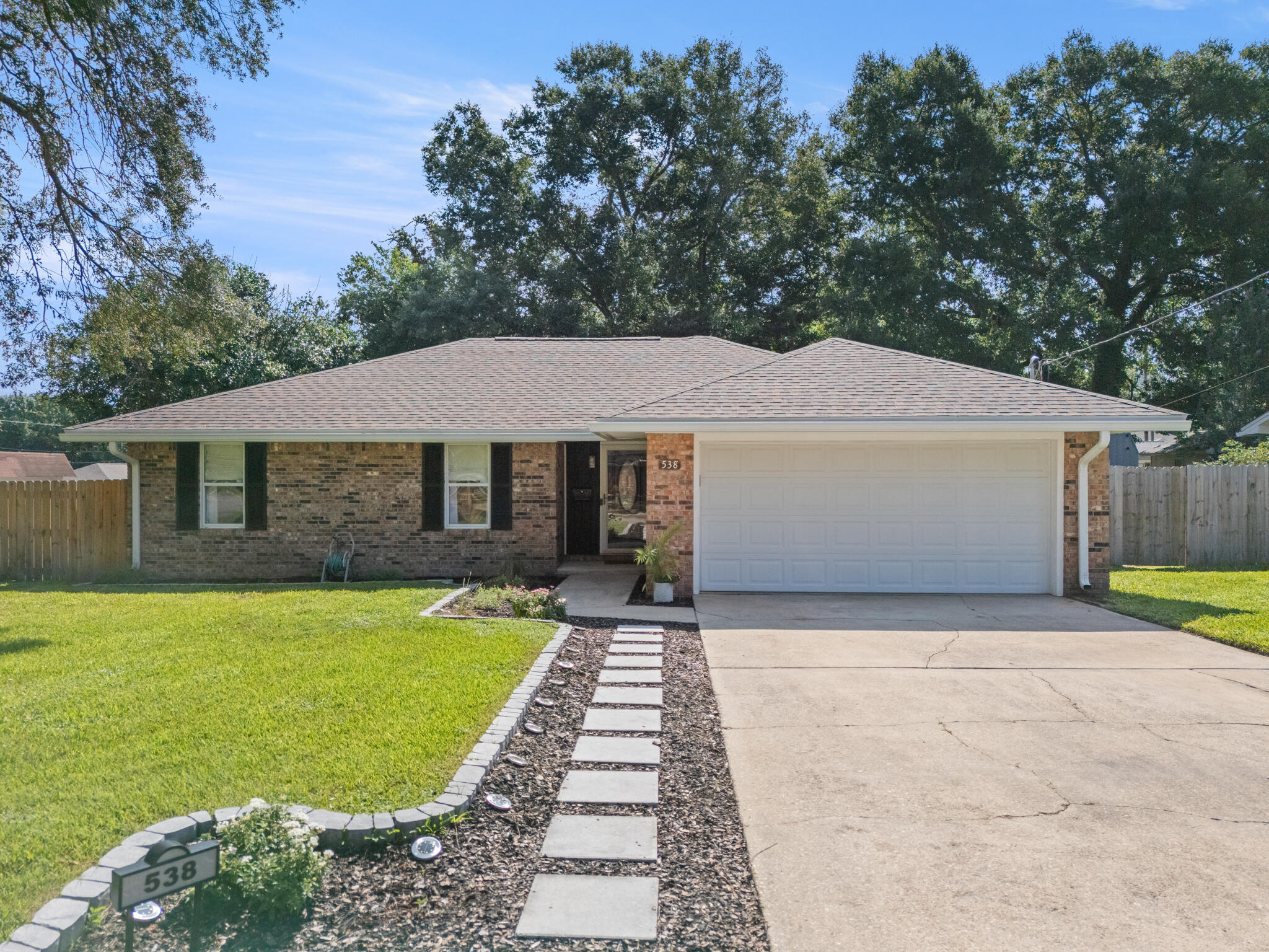 Renovated to Inspire. Staged to Impress. Move-In Ready in Niceville's Carol Ann Manor.On a corner lot in one of Niceville's established neighborhoods, this 2,021 sq ft home blends mid-century character with a sleek, modern revival. Originally built in 1974, it was taken down to the studs and completely reimagined inside and out so you can enjoy the charm of the era without sacrificing today's style or convenience.The kitchen is the showpiece, with quartz countertops, a large center island with hidden storage, open shelving in place of upper cabinets, and textured subway tile that adds depth and dimension. The custom butler's pantry with butcher block counters and smart organization handles the extra storage with ease. An open layout flows through the dining area and into the sunken family room, where a wood-burning fireplace anchors the space. Luxury vinyl plank flooring, designer fixtures, and hand-selected finishes give the home a fresh and intentional feel throughout.
The main bathroom offers everyday luxury with a double vanity featuring brushed brass fixtures, era-appropriate designer tile, and a fully tiled shower and tub combination. The primary suite features two sunlit windows, a walk-in closet with custom organization, and a striking ensuite with ceiling-height tile, a sleek vanity, and glass barn doors.
Enjoy Florida living year-round in the enclosed Florida room, perfect for morning coffee or evening relaxation. The backyard is shaded by mature trees and enclosed by a brand-new privacy fence.
With updates including a new roof, upgraded electrical, custom closets, and thoughtful finishes from top to bottom, this home stands apart from anything else on the market in Niceville. Renovated, staged, and ready for its next chapter.