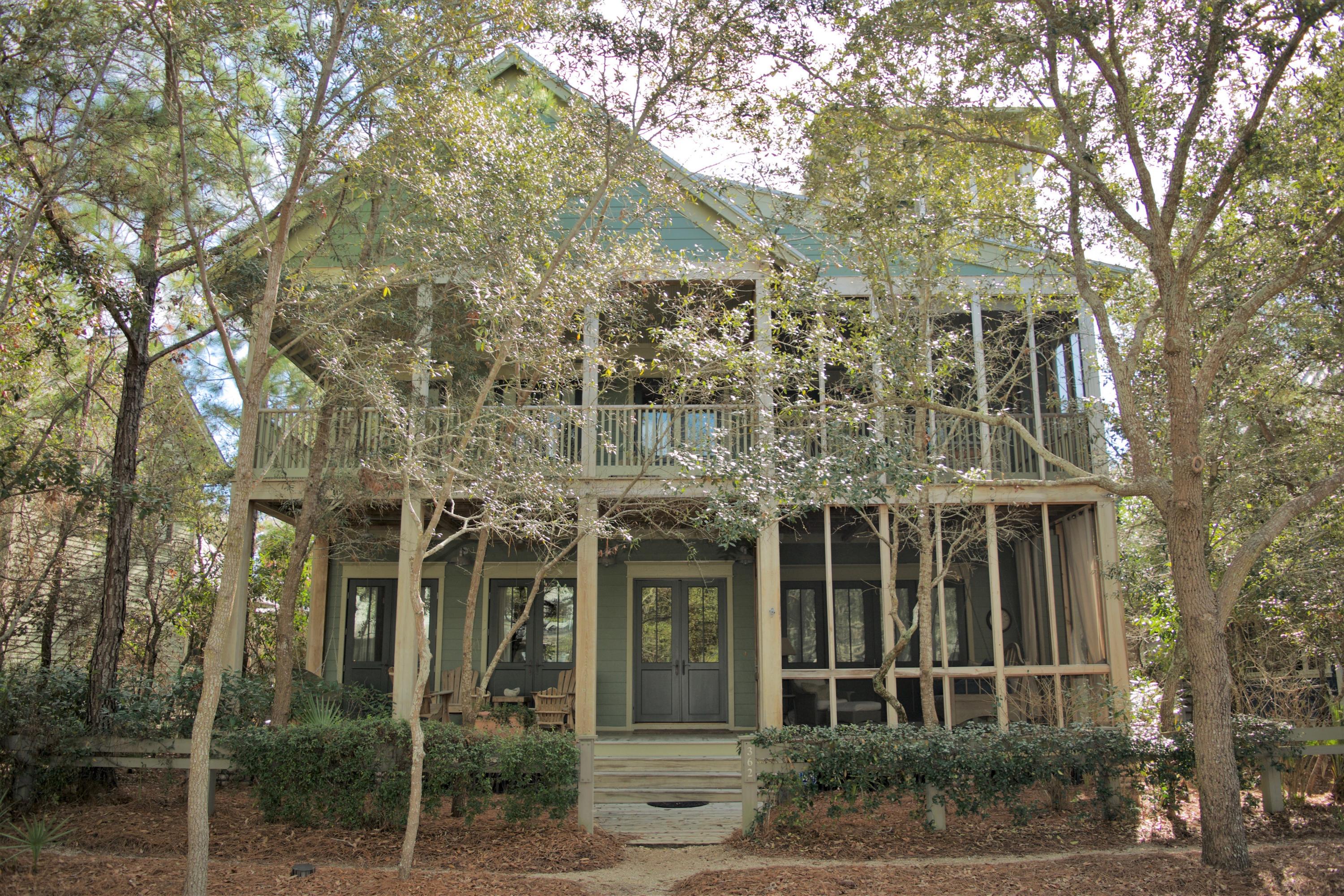 Nestled among the native pines and situated along Western Lake Drive in Phase 1 of the coveted community of WaterColor, this 5 bedroom, 5 -1/2 bath home welcomes you with an expansive covered front porch, warm wood tones and cozy wooden rockers. The exterior of the home is blanketed with desirable outdoor living space on each level, offering two covered verandas and three screened-in porches with hanging beds and comfy outdoor furniture. As you enter the home you are greeted with beautiful hardwood floors, shiplap walls and high ceilings throughout. Warm up next to the stately brick fireplace or kick back and converse in the spacious living room. The open-concept floor plan transports you into the homes expansive kitchen, fit for a chef, offering a large center island with a breakfast bar,