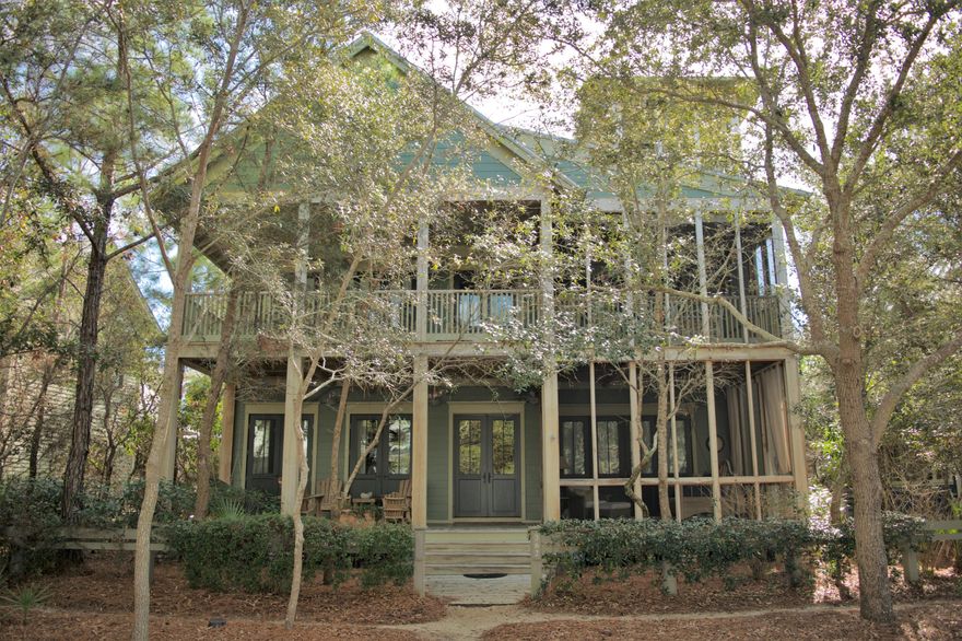 Nestled among the native pines and situated along Western Lake Drive in Phase 1 of the coveted community of WaterColor, this 5 bedroom, 5 -1/2 bath home welcomes you with an expansive covered front porch, warm wood tones and cozy wooden rockers. The exterior of the home is blanketed with desirable outdoor living space on each level, offering two covered verandas and three screened-in porches with hanging beds and comfy outdoor furniture. As you enter the home you are greeted with beautiful hardwood floors, shiplap walls and high ceilings throughout. Warm up next to the stately brick fireplace or kick back and converse in the spacious living room. The open-concept floor plan transports you into the homes expansive kitchen, fit for a chef, offering a large center island with a breakfast bar,