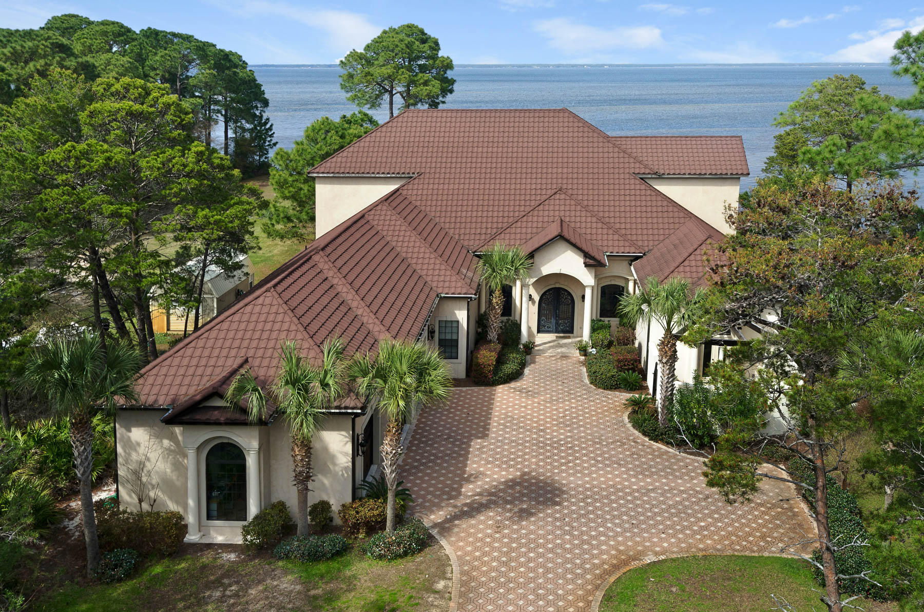 Take a drive down Walton Way in South Walton County. You won't see much more than private gates lining the estates' driveways along the bay. Only Walton Way offers the privacy of 100' of bay frontage, the tranquility of a cul de sac, and the meandering tree-lined driveways of deep lots. Welcome to 408 Walton Way. Built on a 1.15 acre, 500' deep, 100' wide bay front lot, this home is the ultimate retreat. Enter your electronic iron gate and take it slow down your designer pavers. Breathe in the bay air and smile proudly at your tropical foliage. Turn into your three-car garage and relax. You've arrived in your own personal paradise. You notice that the kids aren't home yet as their private wing is yet undisturbed. You take in the beauty of the intricate stonework in your gourmet kitchen and walk in your spacious pantry to consider your dinner options. It's always a pleasure to prep on your cook's island and then to saut???? on your 6-burner Thermador Range.  You grab a good bottle of cabernet from your wine refrigerator and head out to the 2000 square foot screened lanai. You consider a swim in the heated pool but decide that today is a better day to watch a sunset from your private dock on the bay. Back inside, you hear the family arrive. The sound of the opening of the wrought iron door, then the click of heals on the Brazilian Pecan hardwood floors bring a smile to your face. You slide back one set of sliding glass doors to invite the family outside and take in the drama that your 26' tall ceilings create. With over 5,300 square feet of heated and cooled living space, this Mediterranean style retreat allows for complete single floor living but the kids prefer to hang out upstairs. Today they watch a movie in the screening room instead of sunset from the immense covered balcony. You've thought of converting the upstairs to a guest suite since it has its own kitchen but you'll wait until the kids are gone from home. Days end draws you to the luscious master suite. Etta James' soothing croon fades away as you turn off the full house speakers. Another day in paradise. Another day at 408 Walton Way.  Make an appointment to experience this spectacular bay front estate today. 