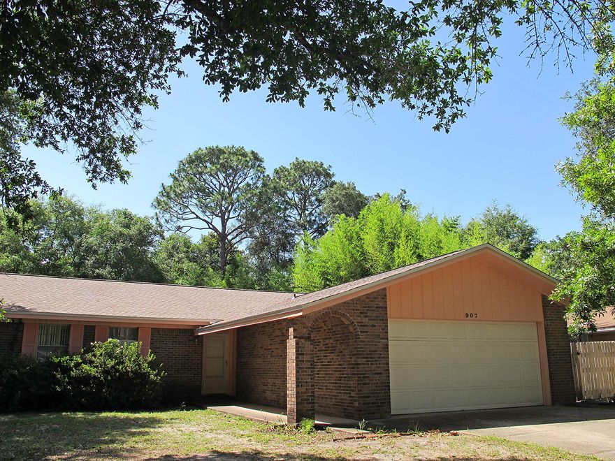 Great bones, great neighborhood! Spacious family home ready for your personal touch. Would also make a great rental investment. BRAND NEW ROOF! Located just a few minutes from Lions Park, a lovely two-acre park on Boggy Bayou with two boat ramps, pavilions, tables, and benches.Enter into the huge sunken living room with a beamed cathedral ceiling and a floor-to-ceiling wood-burning fireplace. A brick half-wall separates the living room and dining area, which has a Tiffany-style hanging lamp. Exit the living room through a sliding glass door into the large, screened Florida room.The roomy kitchen includes all appliances, and has a cutting board built right into the counter top. Behind the kitchen is a large utility/laundry room with built-in shelves.