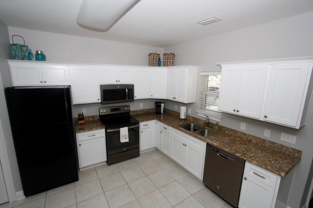 Turn key, ground floor furnished 2 bedroom, 2 bath condo in Topsail Village. All new cabinets throughout and engineered wood flooring in the living room and bedrooms. The unit is just steps from the pool and (1 mi.) from beach access. Condominium has an open living-dining-kitchen area with built-in kitchen desk. Kitchen has granite counter tops, new white cabinets, built-in microwave and pantry. Two baths have granite counter tops. Bath one has tub-shower combination; second bath has a shower.Full size washer and dryer are behind louvered doors. Property is located across from the pool. Park at your front door. Great for residence or vacation rental. (Buyer to confirm all fees, measurements, and other information.