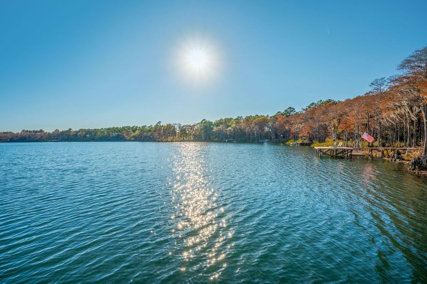 Every day feels like a retreat on tranquil Blue Pond, where gentle water, natural shorelines, & outdoor spaces set a peaceful rhythm. Stunning views greet you from nearly every room, keeping the lake at the heart of daily life. Step outside to enjoy swimming, paddling, fishing, or simply relaxing on the private dock as the breeze moves through the trees. A brand-new roof adds confidence & ease, while the home's comforts support a life centered around nature: enjoy a stone gas fireplace, gas stove, & tankless gas water heater. From the grill house, the Endless Pool, & the private dock, each space is designed to bring you closer to the outdoors. Evenings settle softly over the lake, inviting slow moments & deep breaths where water, sky, & landscape shape every day into a peaceful escape.