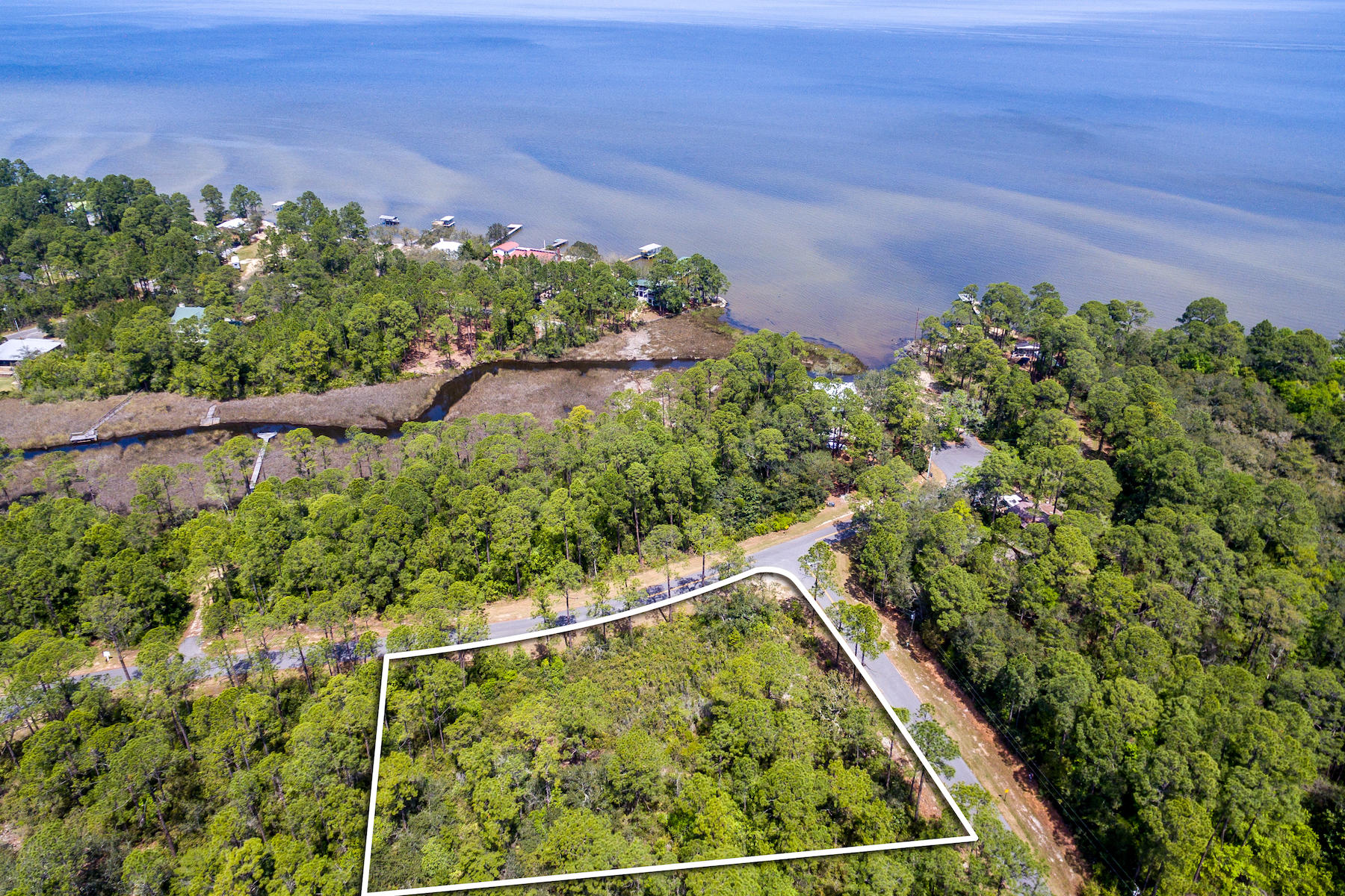 This is a 1/2 acre plus corner lot in a great location just across the street from the bay. The lot has views of the county owned dedicated park area and bay. Lots of room to build main home, carriage house, pool, and more! Public water and sewer available.