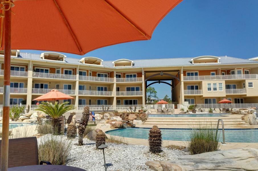 This never rented unit has been meticulously maintained with many upgrades.The location is ideal with beautiful views of the amenities. Master bedroom and family room face Redfish Lake and the Gulf of Mexico. High ceilings, wood cabinets, plank tile flooring, and custom draperies. Sold with furnishings included so all you need is your swimsuit! The 2 guest bedrooms have en-suite baths plus a central powder room for guests. Laundry room with sink. Spacious covered deck faces South. Community is gated with underground parking and elevators which means no stairs to climb and a short walk to the 4 pools and community dock where the water taxi commutes you to the beach! Kayaking, paddle boarding and fishing on Redfish Lake, all included. Live the 30-A lifestyle without the East end traffic!
