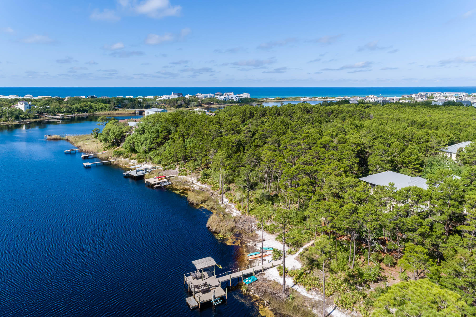 Live the lake life on a rare coastal dune lake, within the secluded gated community of The Landing at Camp Creek. Located on 30A's east end, directly across from Watersound Beach and just 2.3 miles west of Alys Beach. Seize the chance to enjoy picturesque vistas daily on this rare, coastal dune lake of Camp Creek Lake. No short-term rentals are permitted, adding to the quiet privacy. This well-appointed, lakefront residence with carriage house embraces a unique ambiance where coastal nature abounds. It boasts expansive porch views and is surrounded by natural preserves. The large site banks down to your own private dock and natural beach, spanning 68 feet of natural lake frontage and ...