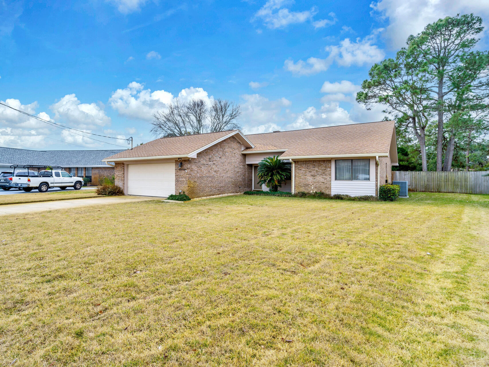 Welcome to this stunning all-brick home, ideally located just off Hwy 98 and minutes from the front and back gates of Hurlburt Air Force Base. Nestled in a unique, well-maintained neighborhood with diverse styles and floor plans, this home is just minutes from shopping, schools, beaches, the mall and neighborhood park! Featuring cathedral ceilings and a striking double-sided brick fireplace, the spacious layout includes a formal dining room and great room, both beautifully separated by the corner fireplace. Eat-in kitchen offers oak cabinets, a breakfast bar with wine rack, and a newer AC unit. Enjoy the enclosed back patio, fenced yard, and sprinkler system. A new roof being installed soon. Plus, Oak Tree Park, with basketball courts, picnic areas, and a playground, is just steps away! The home also showcases an indoor laundry/mud room perfectly placed in between the garage and entrance into the home. 
The master bedroom hosts multiple over sized closets.