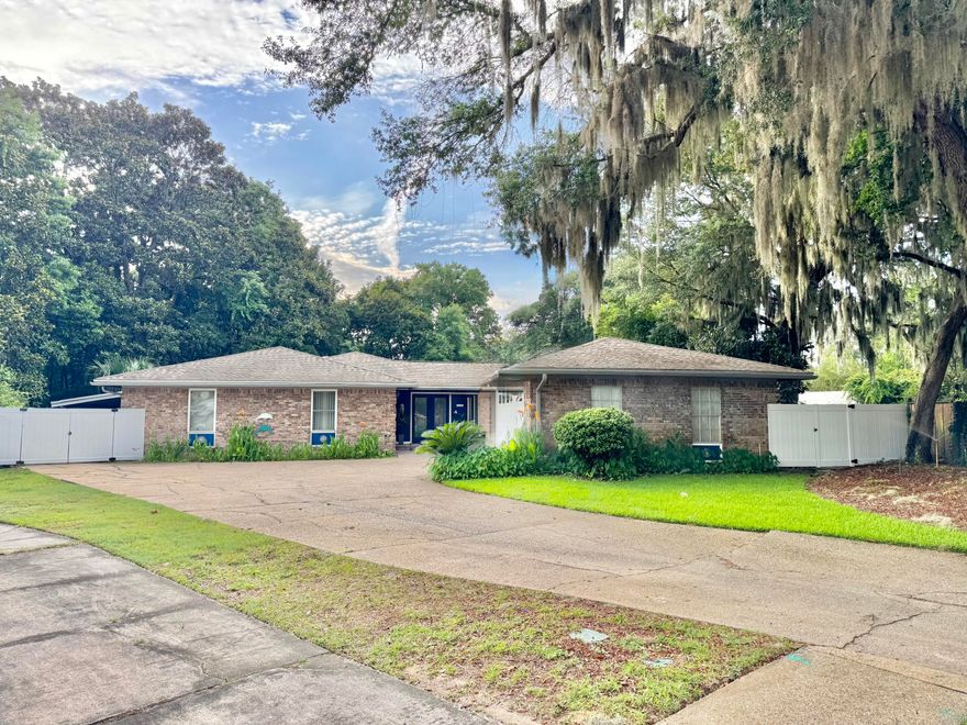 Welcome home to your dream retreat! Nestled in a peaceful cul-de-sac this property boasts almost an acre of lush green grass and an abundance of trees that are positioned for maximum privacy. The combination of privacy and natural beauty makes this home a perfect sanctuary for nature lovers and those seeking outdoor fun. This is a must see as you will notice this is not your average cookie cutter home. As you enter the home you are greeted with beautiful tile floors and a very large open floor plan and with 6 skylights there is an incredible amount of natural light. Kitchen comes fully equipped for the gourmet chef and the laundry room is conveniently adjacent connecting the two car garage. The spacious living area is great for family gatherings or quiet nights with gas fireplace and built in entertainment center. There is a beautiful hand painted ocean mural that adorns the wall above the pella doors that fully open to connect the inside and outdoor experience.  Heading out to the fully screened in lanai you will see a built in hot tub and enough room for plants and furniture. Last but not least is your  sparkling in-ground pool while you admire that gorgeous setting. The home has been well maintained by the owners and have thoroughly enjoyed every aspect of it. HVAC is manufactured by 4 ton Trane 2019 and the roof is June 2025 with many special upgrades including top of the line underlayment, new skylights and architectural shingles. Gas Rinnai inline water heater. Conveniently located to bases, schools, hospital, beaches and shopping. Carport is located on the left side of the home behind the fence and convenient for boat or jet ski storage. Seller is paying for Home Warranty. 