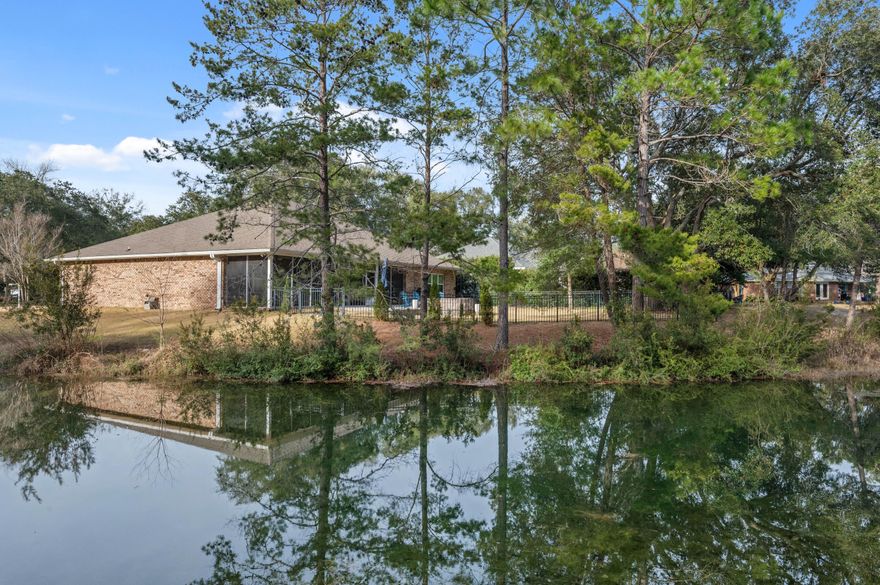 Wake up to stunning lake views and start your day with coffee on the expansive 42' x 10' covered back porch. In the evenings, retreat to your private backyard oasis featuring a beautifully paved patio and firepit, perfect for cozy nights, entertaining guests, and soaking in peaceful waterfront sunsets. Tucked within a charming, small neighborhood in highly sought after Bluewater Bay, this exceptional home blends comfort, elegance, and a relaxed coastal lifestyle. The open, light-filled floor plan features four generously sized bedrooms with plenty of space for guests and entertaining. Designer finishes shine throughout, including wood-plank tile flooring, soaring ceilings up to 12', elegant trey ceilings, and crown molding that adds timeless character The spacious living room with a double trey ceiling and gas fireplace creates the perfect gathering space to relax, read, or host friends. The sleek, gourmet kitchen is both beautiful and functional, showcasing all-wood cabinetry with soft-close drawers, granite countertops, a large island with storage and hop-up bar, and slate finish appliances including a gas range and stainless refrigerator. This exceptional home offers the perfect balance of luxury, comfort, and lifestyle in one of Bluewater Bay's most sought-after locations.