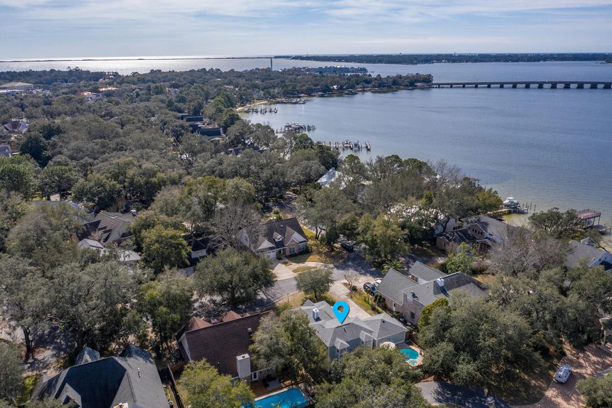 LIVE THE WATERFRONT LIFESTYLE w/ DEEDED COMMUNITY ACCESS TO GARNIERS BAYOU WITHOUT THE WATERFRONT PRICE. Spectacular 3 Bedroom, 2 1/2 Bath, 2 Car Garage Home with POOL & SPA. This remarkable home is tucked away on an oak lined private drive in the quaint community of Palm Shores. Palm Shores offers its residence a community park with deeded access to Garniers Bayou & the bay. Start your day launching your PADDLE BOARDS, CANOES, OR KAYAK directly from the community park. Then come home and relax & unwind in your private salt water POOL & SPA & end your day connecting with friends on your back patio. The pool & spa are heated for year around fun! Rarely does an opportunity come available to acquire a home in this premier community. The southern coastal charm of the architecture & (READ MORE) the calming coastal color palette & expansive wrap around front porch & deck add character to this unique home. From the moment you walk through the front door you feel at home! The light, airy living space with high ceiling is brightened by four sets of french doors that open onto the front porch. The gas fire place offers a warm place to relax during the cooler winters. The home has a very functional floor plan with an open concept, while maintaining designated spaces. You will love the wood floors throughout the home, with the exception of tile in the bathrooms & laundry room. The kitchen offers all stainless steal appliances to include a gas range, french door refrigerator, dishwasher, & microwave. There are ample cabinets, expansive counter space, double sink, & separate prep sink that make this kitchen a chef's dream! There is also a wood top bar that extends into the living area and adds to the character of the home. The kitchen also features a dining nook. Off the kitchen is a perfect bonus space that can be made private with a pocket door & glass door off of the living area. This room would make the perfect home office or formal dining room. The Master Bedroom is tucked away on the 1st floor offering ample privacy from the guest bedrooms on the 2nd floor. The Master Suite is spacious with a large walk-in closet and updated Master Bathroom. The Master Bath features a large garden tub, separate walk-in shower, & granite top vanity. The Master Suite is enhanced by its access to a private back deck overlooking the sparkling pool. This is the perfect place to enjoy a cup of coffee in the morning or a glass of wine in the evening. The laundry room is conveniently located on the 1st floor & is a large multifunctional space with extra storage and a 1/2 bath. The 2nd floor features 2 additional Guest Bedrooms with ample closet space & each bedroom has its own private balconies. Centered between these bedrooms is the Guest Bathroom with large garden Tub / Shower. For added peace of mind, the exterior of the home was complete painted in 2019, the roof & gas hot water heater are only 8 years old, the pool has been updated in the last 1+ year with a new gas heater, new pool pumps, & new sand filter. To add to the FLORIDA LIFESTYLE, the home is located within 1 mile of Shalimar Yacht Basin & Marina. The home is also located 0.3 miles from Meigs Middle School & 1 mile to Shalimar Elementary School. DON'T Miss Your Opportunity to Call this wonderful place HOME! Call your Realtor Today!