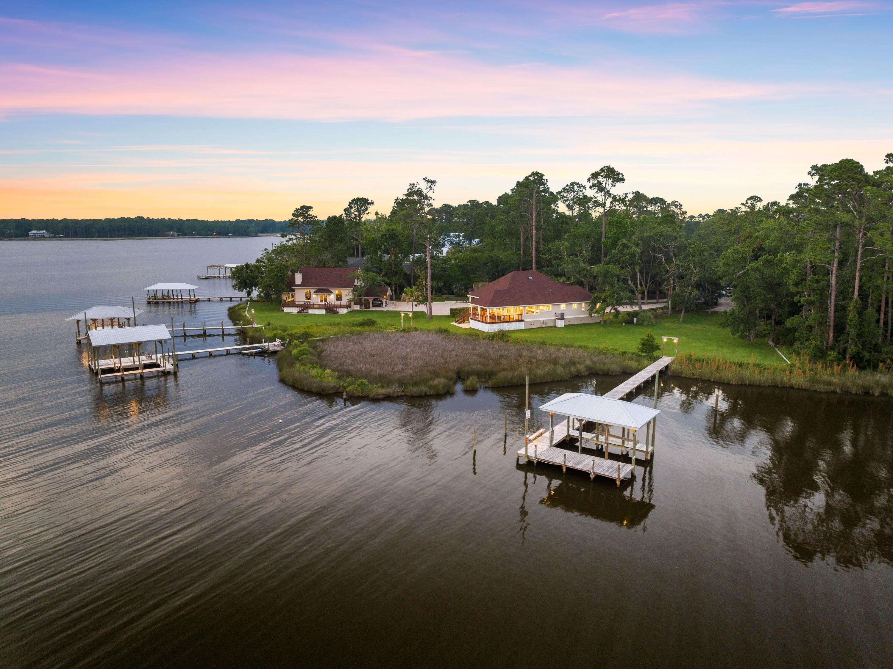 Welcome to your new waterfront retreat on Lagrange Bayou where it's all about the views and coastal lifestyle.  This unique 6.8 acre offering, encompasses two single family homes, an additional cottage that could serve as a guest home, workshop, or home office, and three docks with 725 ft of waterfront.   The beautifully updated main home offers a split plan, 3 bedroom layout on a single level with cathedral ceilings and a wall of windows to capture the perfect sunsets.  No expense was spared on updates to include custom walnut cabinets, quartzite countertops, hardwood flooring, and hurricane rated doors and windows. The covered cumaru deck on the south side of the main home is the ideal spot for dining or relaxing with stunning views of the bayou and bay. Enjoy refreshing breezes from the Choctawhatchee Bay, even on the warmest days.  The second home on the property offers the flexibility of multi-family living on the estate, a guest home, or opportunity for rental income.  This home comprises 2 bedrooms and 2 bathrooms with a large galley kitchen complete with hickory cabinets and natural stone countertops.  This unique 2 story layout feels like a retreat with the upstairs offering a private bedroom with on suite bath, and library, while the downstairs space features panoramic water views and fireplace for the cooler seasons. This home is also where you'll find the covered parking.   The third structure, currently serving as a workshop space,  boasts a sleeping loft and bathroom which allows the property to convert to another guest space, private office, or man cave.  Just beyond the seawall you'll find 3 docks with open boat houses, boat lifts, and catwalks already in place and ready to enjoy- just bring your boat or jet skis! Not only is this a private sanctuary for families to enjoy, but it serves as home to eagles, osprey, and deer not to mention the dolphins who swim through on a regular basis.   The additional wooded land offers a unique position for the next owner to simply secure their privacy, build additional personal structures, or consider development opportunities. 