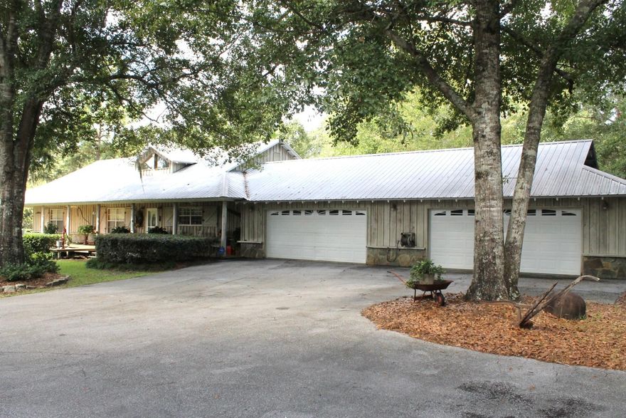 Fantastic opportunity to purchase this private country style home located on 4.5 acres of pristine acreage accented with white tail deer, turkey, mature cypress, oak, pecan and persimmon trees. This custom built home has a very large kitchen with breakfast bar, family room, office, gorgeous covered porch, recessed lighting, vaulted ceilings, custom fireplace, outdoor hot tub and a 24x48 four car garage. The 22x20 master suite has vaulted ceilings and huge walk-in closet with private bath. In addition to the garage, there is 30x40 pole barn/carport that can accomodate all of your toys, to include that fishing boat. The home also has a custom built 20x24 ''cook shed'' that is perfect for family gatherings. There is also a 40x60 commercial building on the property with 3 roll up doors.