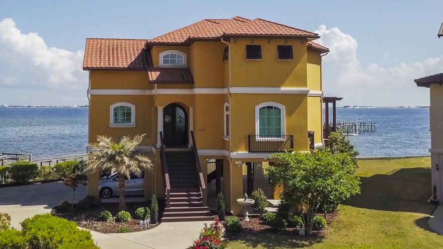 NEW PRICE ADJUSTMENT! This stunning Mediterranean-inspired waterfront home sits majestically on the shores of the Santa Rosa Sound, with private beach and Gulf views, within beautiful Palmetto Lake Preserve, one of only a few gated communities in Navarre, FL. This is a unique opportunity to purchase this custom home, recently built in 2012, new to the market for the first time. This home has been thoughtfully designed by local designer, Doug Whitfield, meticulously maintained, and is truly a GEM on the shores of the Santa Rosa Sound, with a luxurious coastal open floor plan, and seemingly endless outdoor living spaces for entertaining and relaxation. The property conveys with a deeded boat slip on the private community pier maintained by the Homeowners Association.