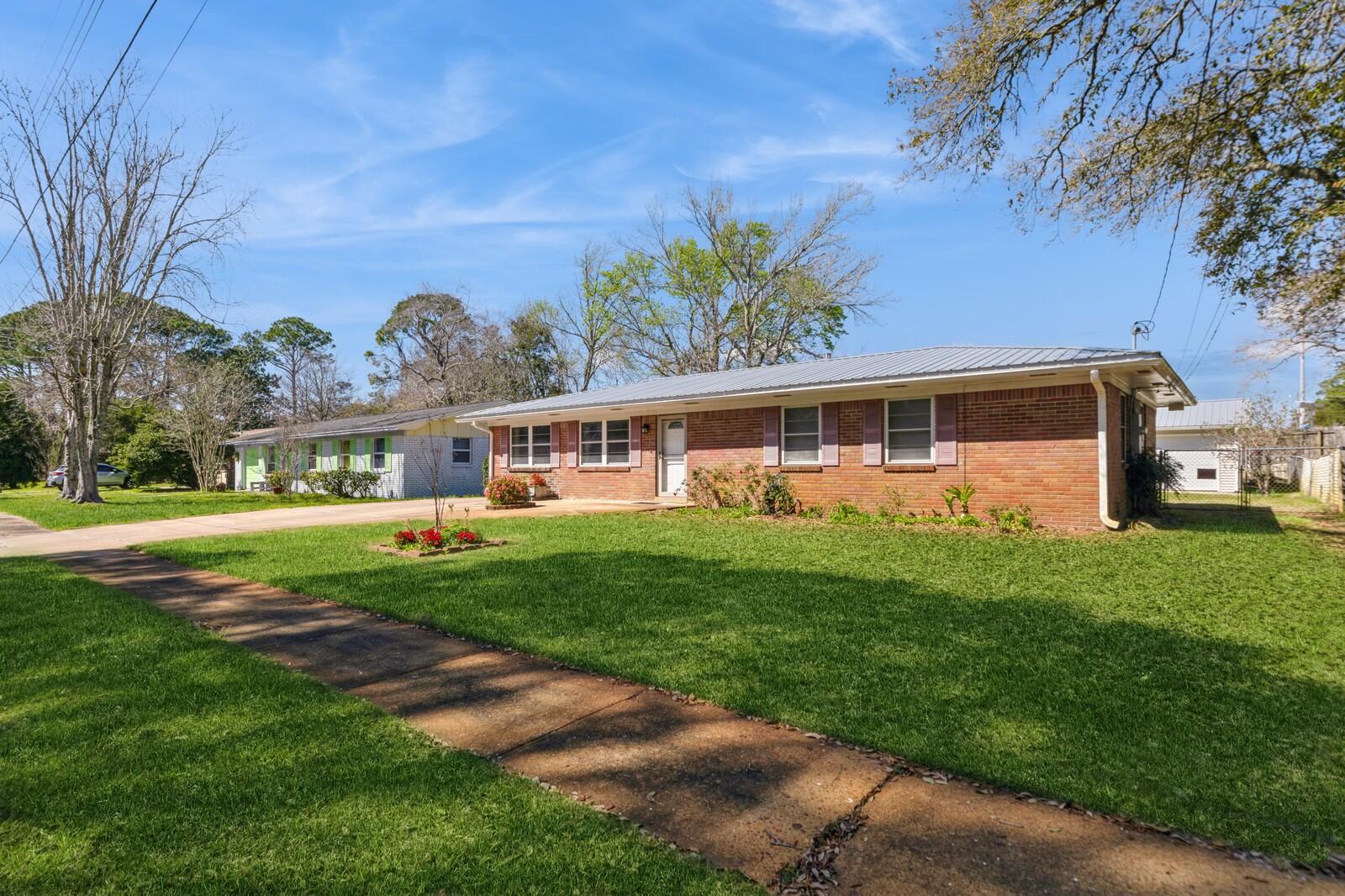 All brick home. The kitchen and both bathrooms have been updated. We have 20x30 storage garage with electricity in the back with access from the front. When you walk into your home the formal dining is to your left with a hall to your right. The kitchen is toward the back of the house and the family room is to the left of the dining. Through the eat in kitchen you have a large Florida room 280 sq ft with separate AC -Great to entertain your family. Down the hall you have your guest bathroom to your right and your two guest bedrooms to your right. Your master bed and bathroom are at the end of the hall to your left. Fenced in back yard with lawn pump. Hardwood floors and tile. Large inside utility room with plenty of storage right off the kit The lawn pump is on a timed sprinkler system. This home was loved just look at all the flowers!