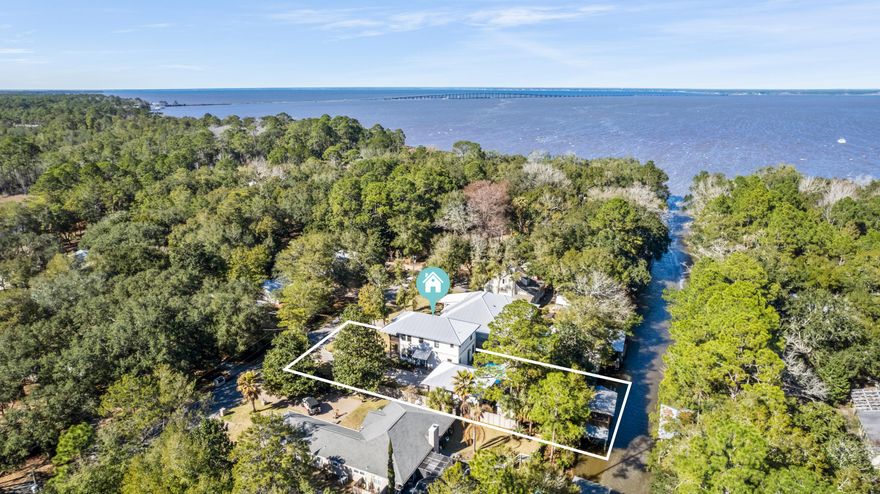 WATERFRONT-NEW CONSTRUCTION-TWO BOAT LIFTS-HEATED POOL-POINT WASHINGTON-NO HOA - This custom canal front house, finished in December 2020, is perfect for those who want to be close to the beach but reside in a tranquil low-density neighborhood on the water with boat access. The two-story main house contains 2 master suites, 2 secondary bedrooms, and 3.5 bathrooms. The open concept kitchen, dining, living area and main master suite comprise the first floor, with the second floor comprised of the second master suite, the remaining 2 bedrooms, a shared bathroom, a separate living area, and screened in balcony. A separate heated and cooled pool house contains a full bathroom and could be used as a small efficiency living space, office, workshop, or anything else you can dream up. The interior of the home exudes a modern coastal feel with gray shaker style cabinets, quartz and marble countertops, Norman Soluna shades, and stainless-steel appliances. The home's exterior shines with customization and quality, including: concrete paver driveway and pool deck; Trex patios and balconies; galvanized artistic gutters routed underground; 8 foot tall privacy fencing; lush landscaping; stand-alone storage shed/shop; and heated pool. The most unique aspect of this property is its double decker waterfront feature which includes: a dock and seawall running the length of the property; two boat lifts (an uncovered 10,000 pound cradle lift and covered 4,000 pound strap lift); a viewing deck; and a screened in boat house  all of which have views of the bay. Even though the lot is waterfront, it is high and dry in flood zone x. All appliances are included.  Water heater is tankless powered by propane. This house is a must see!