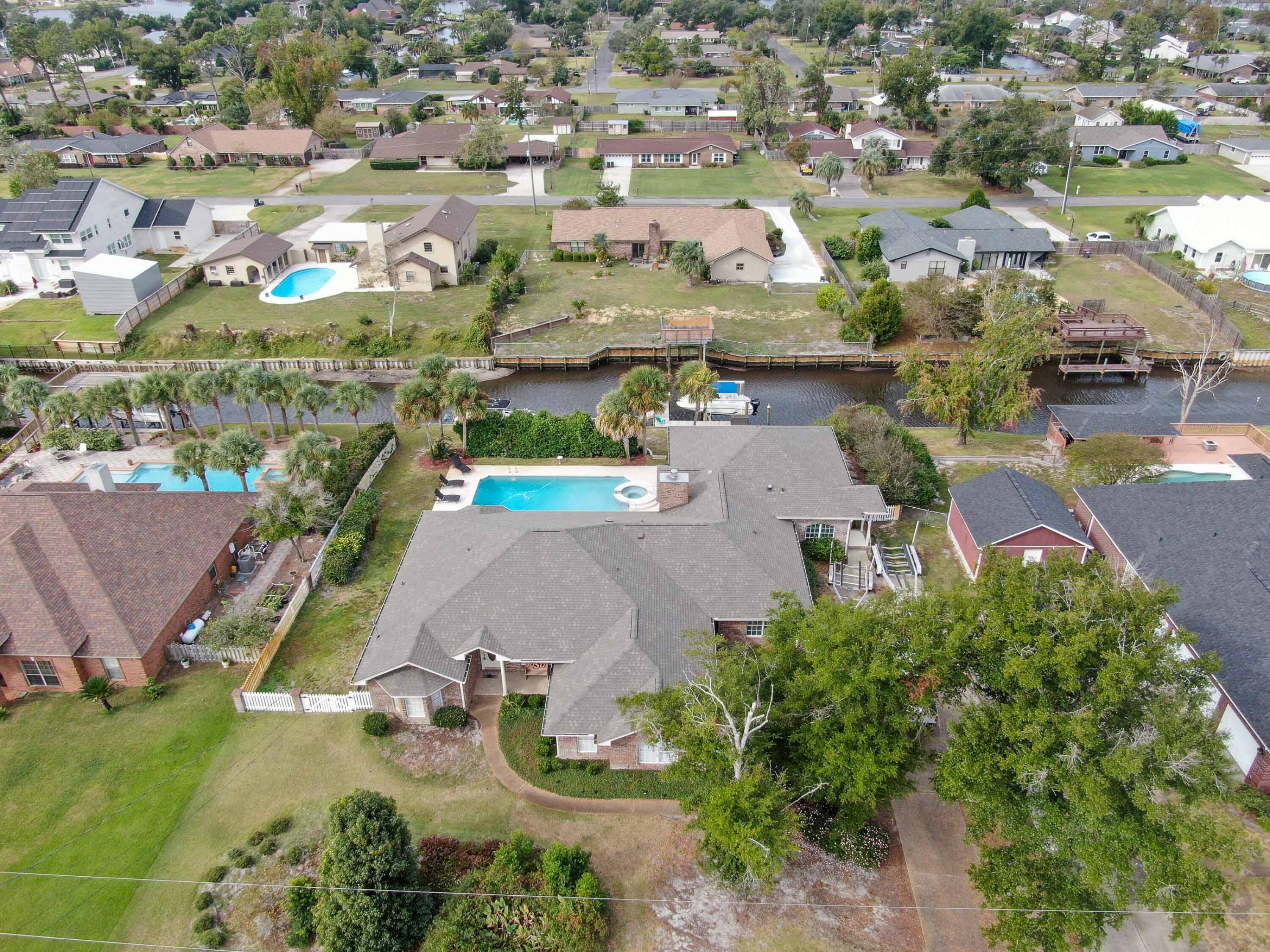 Executive home in Kings Point. Canal front property with bay access. This house is perfect for entertaining. Master suite with bay window, beautiful master bathroom featuring a deep garden tub with built in speakers, a separate shower, and walk-in closet. Interior features a split bedroom plan with 5 bedrooms, dining room, and office. Gourmet kitchen with quartz countertops, stainless steel appliances and breakfast bar. Large family room and a wood burning fireplace. Incredible entertainment room with a bar, wine refrigerator, sink, and a theater room equipped with surround sound and leather chairs. A mother-in-law/guest suite with a separate entrance. Exterior features canal in back with access to St. Andrews Bay and the Gulf, Home has a dock and 10k lb boatlift. Close to Hospitals