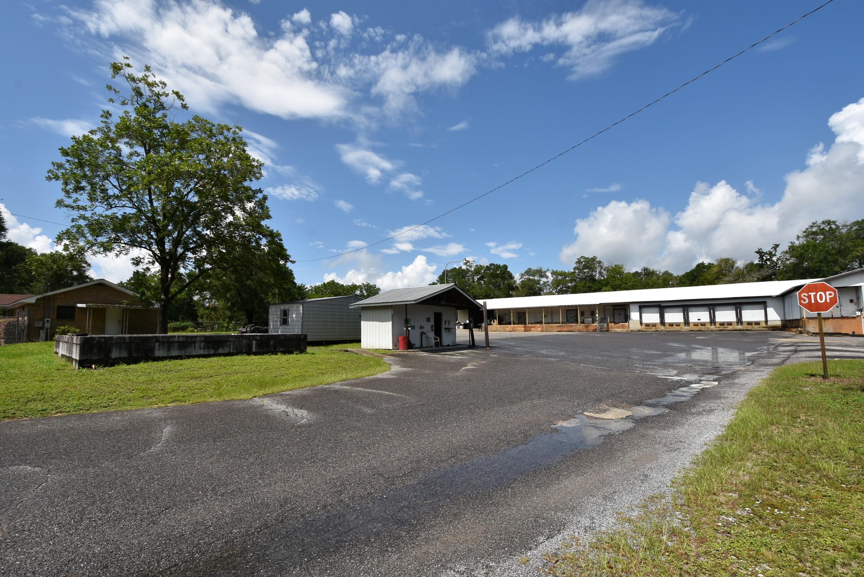 What a find! Property fronts on Industrial Ave and Green St. A mix of Office space, Garage, warehouse, open storage, former freezer/cooler warehouse and Ice House (both are not operational and ''AS IS''). Fully fenced cleared area with additional wooded property on the north side of the property. Paved parking area inside the fenced area and on the Green Street frontage in front of the Office. Lease on the parking area, renews in January. Lot dimensions are approximate. Pictures are a good portrayal of the buildings and the entire property. Office was built in 1976, 1250 SF. Warehouse was built in 1968, 8770 SF. Workshop/Garage built in 1985, 2400 SF, and the Ice House was built in 1973. Utilities have been off for years and will not be turned on for any inspect. Selling strictly ''AS IS'