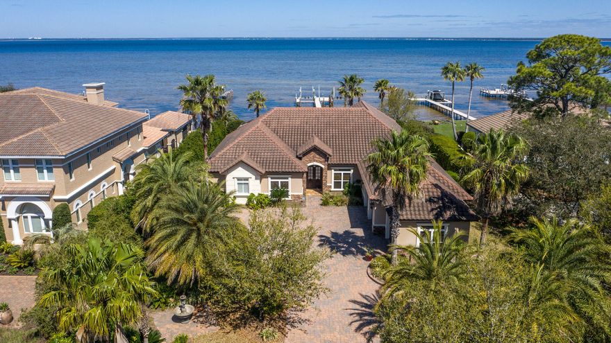 Absolutely gorgeous custom built bay front home in desirable Kelly Plantation.  Fabulous and functional single story floor plan with a great room, formal dining room, open concept breakfast/kitchen/family room, split bedrooms, office, game room and more. Kitchen features granite counters, 5-burner gas range with double ovens, lots of cabinetry, large walk-in pantry.  Luxurious master suite with direct access to the lanai, dual walk-in closets, a huge walk-in shower and oversized jetted tub.  Three additional bedrooms, all with private baths.  Handsome study with built-ins.  Large screened lanai with covered outdoor living area, summer kitchen, pool and spa.  Private dock with two lifts.  Three-car garage.  Loads of custom features! Flood insurance not required. Don't miss this one!