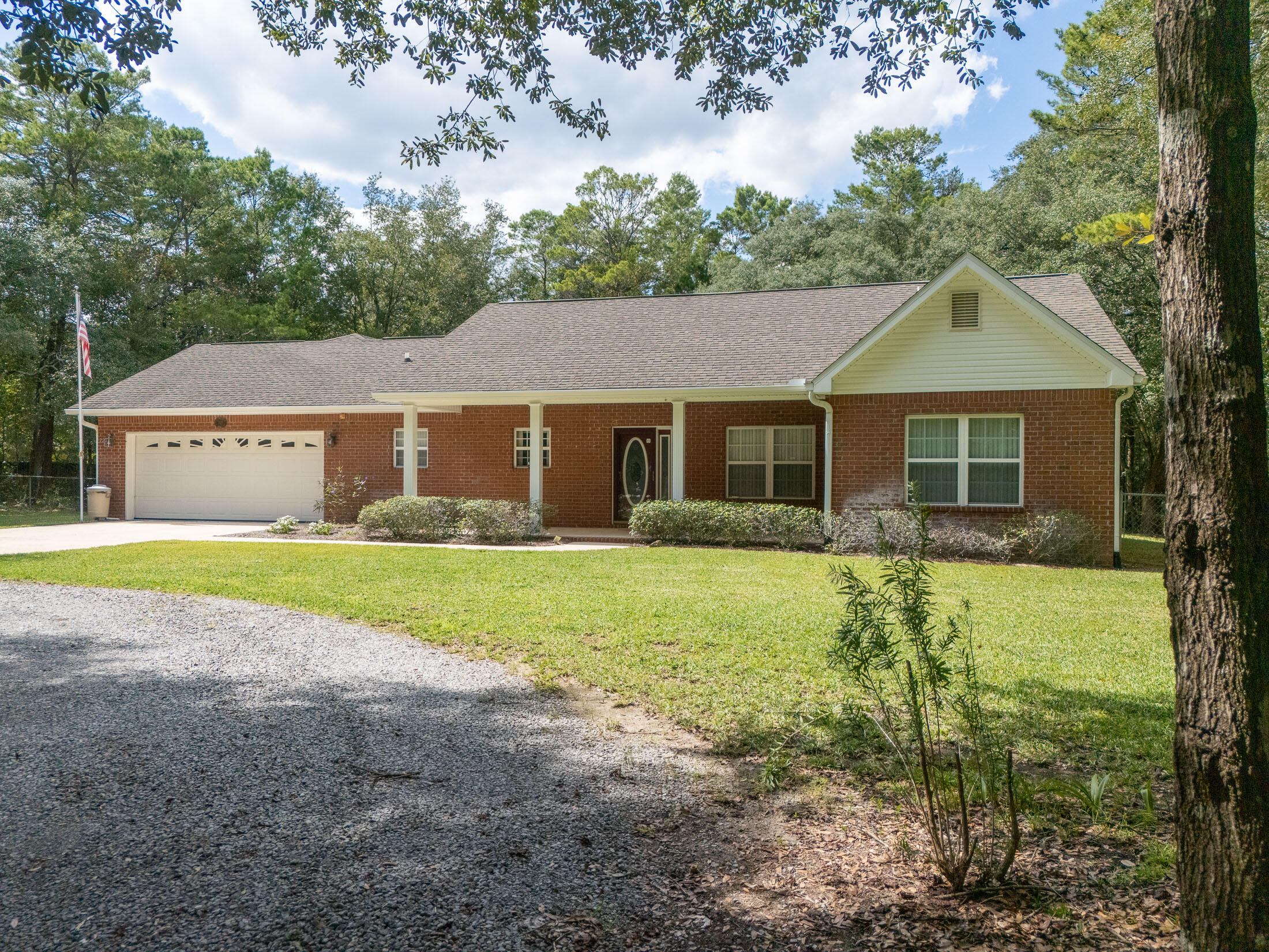 Enjoy wooded privacy and seclusion on this 3 acre estate, with an ideal location; just north of Hwy 90, less than 5 minutes to I-10 and equidistant to Crestview & DeFuniak Springs. This one-owner carefully maintained brick home offers space, convenience and is tucked away from the road and all neighbors. The vaulted ceilings upon entering the living room create volume and openness. The sizable kitchen, with classic white cabinets and tons of counter space, opens up to the breakfast area. A corner fireplace keeps things cozy. The master suite has a brand new walk-in shower and double vanity. There are some handicap features such as grab bars and wide hallways also. Easy maintenance is achieved with a central vac system and utilizing tile in the living and wet areas.  Laundry and storage are a breeze in this roomy utility room. The lot is mostly shady with mature trees except right around the house and the site is almost entirely fenced. A circular drive makes for easy access and the oversized garage with utility sink can fit most any vehicle. There is also an additional workshop for storage or hobbies. Because it is not easily seen from the road, either the front or screened back porch would be a quiet spot for gathering with family and friends or simply relaxing with a cup of coffee. In addition to being serviced by Mossyhead Water, you'll find a deep well also. Cost saving features like a brand new roof is sure to last many years to come. The HVAC is appx 6 years old. This would be perfect for anyone commuting to any military bases or needing quick and easy access to I-10. It feels like a country setting with easy access to shopping, dining and Blackstone Golf Course. 