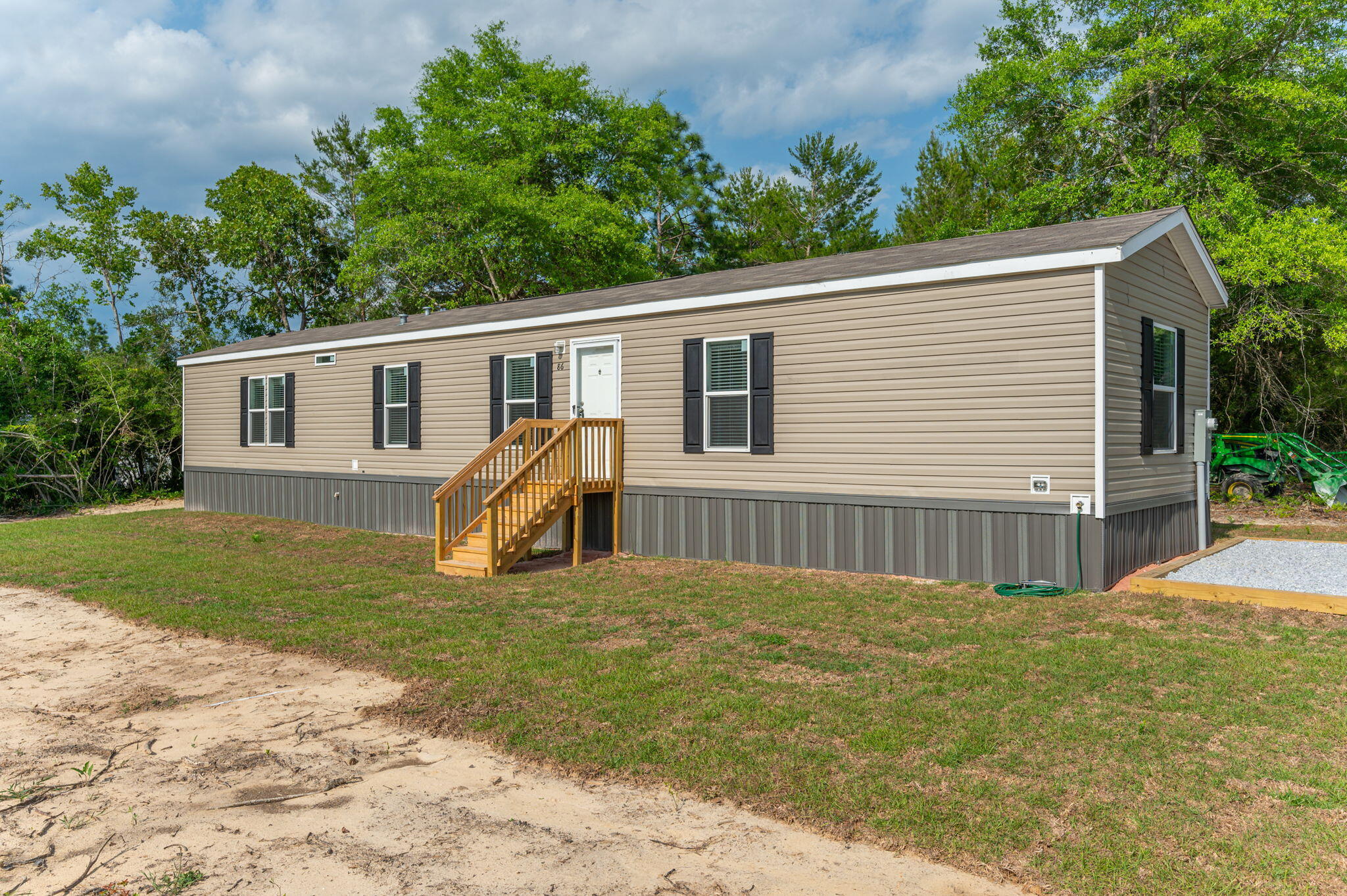 Welcome to this charming 3-bed, 2-bath manufactured home, where modern comforts meet rustic charm. With 1080 sq ft of living space, enjoy unique finishes, stainless steel appliances, and built-in shelving throughout. No carpet, just sleek vinyl flooring. Retreat to the primary suite featuring a walk-in closet, separate shower, and oversized tub. Outside, find newly planted sod, a gravel driveway, and underground power on .23 acres. Conveniently located minutes from town, 20 mins to Crestview, and under an hour to Eglin AFB and the stunning beaches of the Emerald Coast. Don't miss out!