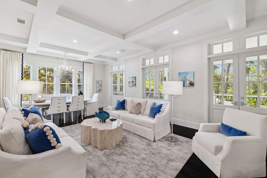 This stylishly renovated non-rental Florida cottage is located on a quiet street within the beach community of WaterColor's Phase III. It enjoys scenic views across the lush preserve and has access to miles of boardwalks and trails -- perfect for an early morning saunter through the community to the bridge, tennis courts, or quickly access your favorite Seaside, Florida, cafe for brunch.  Situated on a carefully landscaped lot, this four-bed home greets you with a traditional front porch. Relax on the swing and take a moment to appreciate the serenity, broken only by the harmony of birdsong. The door opens into a light-filled great room with windows on every side. A white coffered ceiling adds to the sense of spaciousness while dark wood flooring grounds the dedicated living space. A grand fireplace attracts attention, flanked by built-in bookcases. Boasting pristine furnishings, the comfy sitting area is ready to be filled with happy chatter and memory-making. The adjoining dining area is lit by a classic chandelier. French doors open wide onto an oversized screened porch, which has beautiful views of the surrounding greenery. Retreat to the expansive outdoor sitting area to relax and socialize, or head down the steps to the barbecue terrace for a true outdoor dining experience beneath shady mature pines. There's a cozy fire pit and ample space to add a pool or carriage house at a later date. The open kitchen is the hub of the home with a generous central island topped with cool marble. It can easily seat four diners for breakfast or pre-dinner drinks. Immaculate white cabinets match the tiled backsplash and the white hood above the new cooktop range. To one side, a wet bar serves as a coffee station or cocktail bar, depending on the hour. An attractive guest suite with an ensuite shower room and a separate half bathroom is also located on this lower level.  A sweeping staircase leads up to the second floor, which has two additional bedrooms and a family-sized bunk room. The master suite has a truly regal air with a canopied bed and a vaulted ceiling, adding to the drama. Dual-aspect windows offer views of the surrounding greenery, while a door opens onto a full-width porch overlooking a peaceful walking trail. A hammock provides the perfect place for an afternoon nap. Ideal for anyone seeking peace and privacy, this pristine, fully furnished beach house is perfect for full-time living or as a vacation home, with excellent rental potential. It includes a paved driveway and a carport, which is structurally prepared to convert into an enclosed garage.