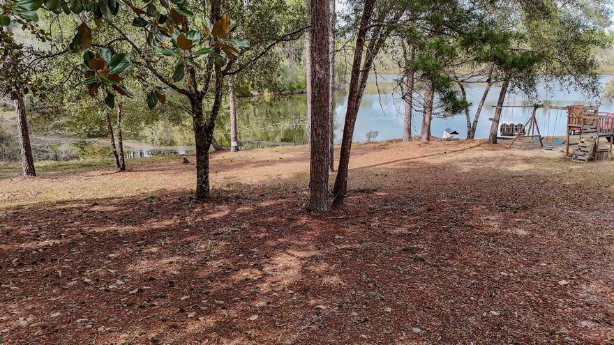 This Magnolia Lake waterfront lot with nearly 100' on the water is one of the largest and nicest in the small, quiet community. Located 5 minutes from downtown DeFuniak Springs, nearby to schools and parks, and has a single entrance in and out of this restricted community. The lot has some nice trees with all underbrush cleared, so it's easy to envision living the lake life. It is well located adjacent to the common area that includes a dock and pavilion. The slope is gentle leading to the water. The lakefront lots have a minimum of 1500SF heated & cooled with no build out time, so you can hold for investment and build later as well.