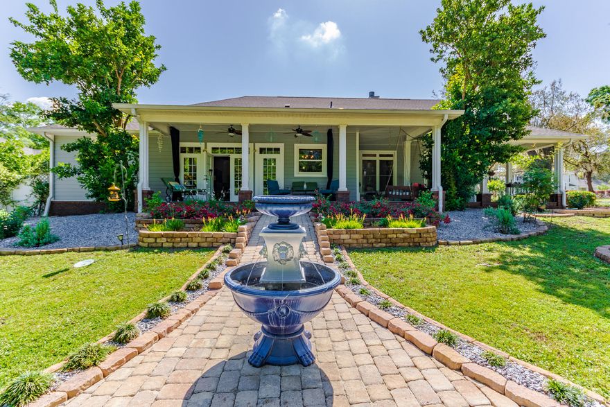 Welcome to an elegant Southern style home with special high end features throughout. At the end of the cul de sac, you enter through a lovely courtyard with ceramic tiled flooring to a beautiful lit arbor. A fire pit adjoins this area making the entire courtyard a beautiful exterior entertainment space. Lemon, orange, grapefruit and pomegranate is healthy and growing in the garden with lights on each tree. Porches surround the front sides of the home; one has screen curtains that close to keep out the insects. This porch adjoining the den is a wonderful place to relax with a view of the tiered garden with fountain,
