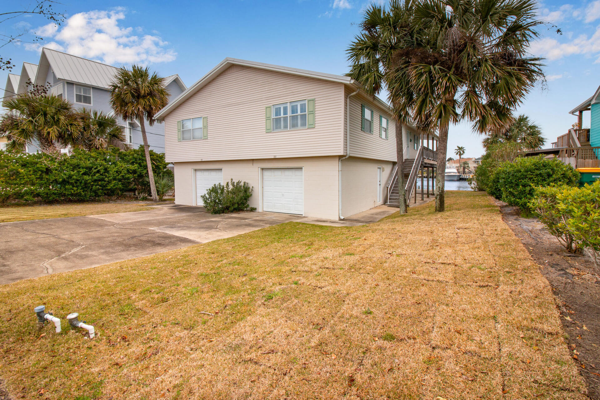 Perfect for Investment or Family Retreat! Two 2 bedroom mirror units in this Canal front home on Holiday Isle in the Heart of Destin.  One side has a studio with a bath on the garage level - the other has enough space to park 4 vehicles.  On the main living level, each side has an ample living area with waterfront views, kitchen with breakfast bar and two spacious bedrooms.  Both sides share an expansive deck overlooking the canal.  Perfect for relaxing or entertaining and watching the leisure watercraft as they traverse the waterway to and from the Harbor, Crab Island and the Gulf.  Large patio underneath the deck and personal 'beach' along with the dock with shower offers your personal access to the waterways.