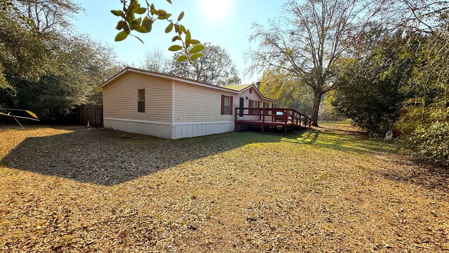 Well-maintained 1999 manufactured home on a spacious 0.29-acre lot--bring your chickens and enjoy country living with modern comforts! This home features a 2015 metal roof, updated plumbing, and a Hydrotherapy Massage walk-in tub (2022). The open floor plan offers a split-bedroom layout for privacy, a kitchen island with new stainless steel appliances, and tile & laminate flooring throughout. The master suite includes 2 walk-in closets and a double vanity. Outside, enjoy a fenced yard with double gates,  a yard building, and plenty of space for RV parking, a pool, or a garage. Relax on the screened-in porch (2020) or use the handicap-accessible ramp for easy entry. Agricultural zoning adds flexibility--schedule your showing today!