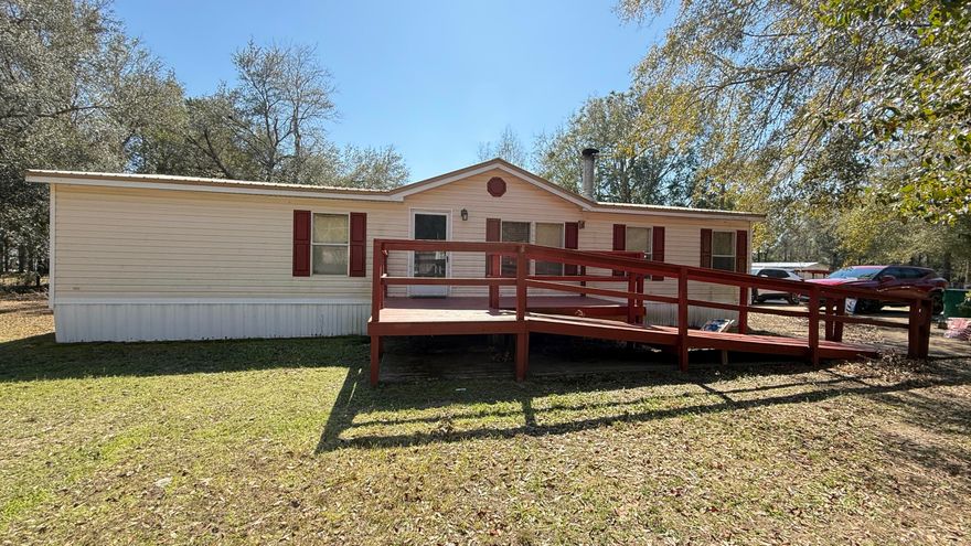 Well-maintained 1999 manufactured home on a spacious 0.29-acre lot--bring your chickens and enjoy country living with modern comforts! This home features a 2015 metal roof, updated plumbing, and a Hydrotherapy Massage walk-in tub (2022). The open floor plan offers a split-bedroom layout for privacy, a kitchen island with new stainless steel appliances, and tile & laminate flooring throughout. The master suite includes 2 walk-in closets and a double vanity. Outside, enjoy a fenced yard with double gates,  a yard building, and plenty of space for RV parking, a pool, or a garage. Relax on the screened-in porch (2020) or use the handicap-accessible ramp for easy entry. Agricultural zoning adds flexibility--schedule your showing today!