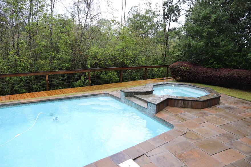 SELLER OFFERING A $10,000 RENOVATION ALLOWANCE. Over 1/4 acre parcel with CONSERVATION AREA behind the home. LARGE POOL and HOT TUB in a gorgeous backyard area. Large boardwalk along the conservation area. Home is very large, with 5bd and 4.5bth. MASTER ON THE MAIN FLOOR (along with the laundry room). Upstairs has 4 bedrooms with 3 full bathrooms, all bedrooms have walk-in closets. One of the rooms is extremely large with a kitchenette. NEW AC's IN 2019. Large living area with cedar-sided walls. Fireplace in the living room and master bedroom. Separated shower and jetted tub in master bathroom. TONS OF BUILT-IN's throughout the house. Under house storage. Two office areas. Gas cooking. Large granite eating area. NO CARPET ANYWHERE. EASY TO SHOW.