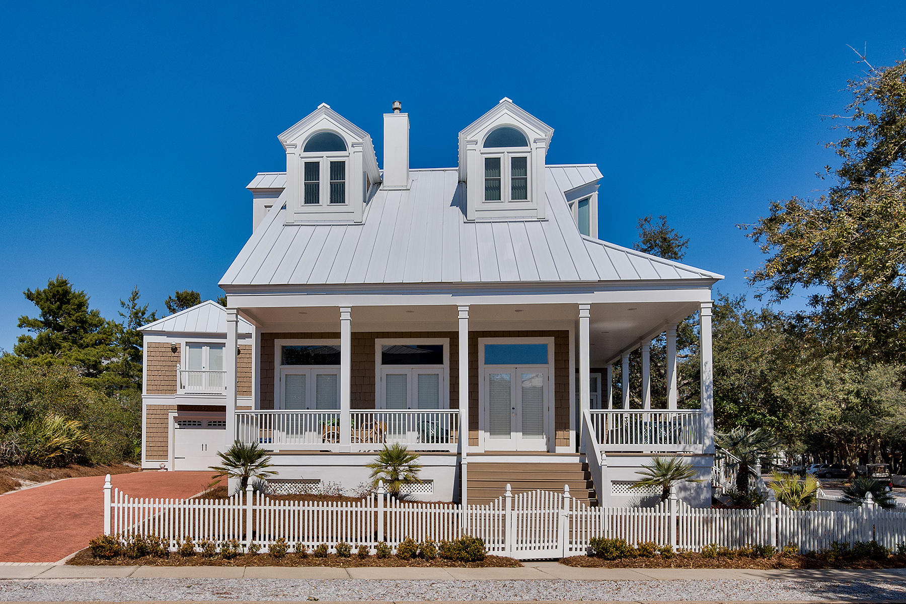 Set behind a scalloped white picket fence, this charming New England-style home features a gabled roof, twin dormer windows and expansive porches for enjoying an outdoor lifestyle. Designed as a custom built home and meticulously maintained by one careful owner, it is one of the largest and most alluring residences in Carillon Beach. The superior features continue inside with polished wood flooring, a peninsula fireplace and a synergy of open-plan dining and living spaces. The sophisticated kitchen includes a cordial mix of glossy quartz and granite, shiny stainless steel and beautiful cabinets, creating an appealing yet fully functional work space. Light and airy bedrooms are complemented by modern bathrooms with a free standing oval tub&#8203;, heated floors&#8203;and separate shower i