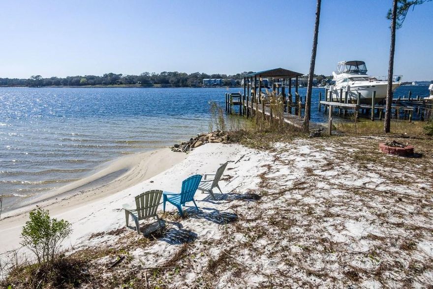 EXCEPTIONAL waterfront property1.16 acres on the protected deep water of Boggy Bayou with approximately 100' of shoreline, private sandy beach area, large multi-level entertainment deck surrounding a refreshing pool and AMAZING sunset views! This 4 bedroom, 3 bath home with multiple living areas has been completely updated and is ready to move into! When you enter the foyer, you will admire the beautiful staircase and high ceilings expanding into the living room to the right. The large living room is accented by a beautiful fireplace and has pocket French doors leading to the den. The den, with its wall of windows, offers amazing views of the yard and bayou beyond. Just off the living areas is the completely renovated eat-in kitchen. This kitchen featuring an abundance of custom cabinets,