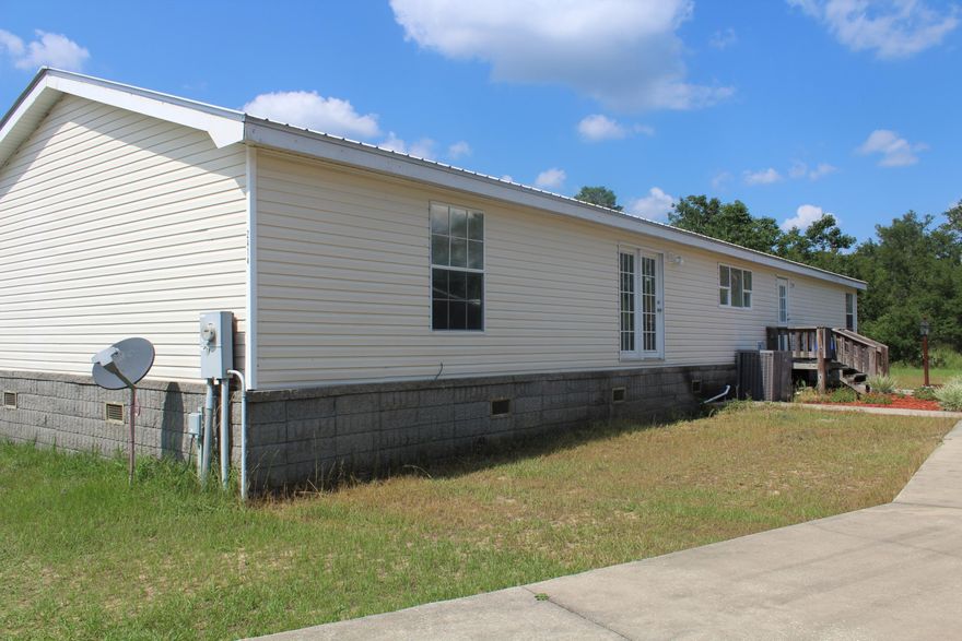Four bedroom, two bathroom manufactured home on one acre with over 2000 sq ft! This home has an open floor plan with a living room and family room. Along with having a split floor plan with master suite on one side of the home and the additional three bedrooms and one bathroom on the opposite side of the home. There are so many extras to this property which includes a large concrete drive way ($10,000), two double carports, storage shed and 10 ft tall chain-link fenced back yard! Easy convenient location to the Emerald Coast or even Bay County!